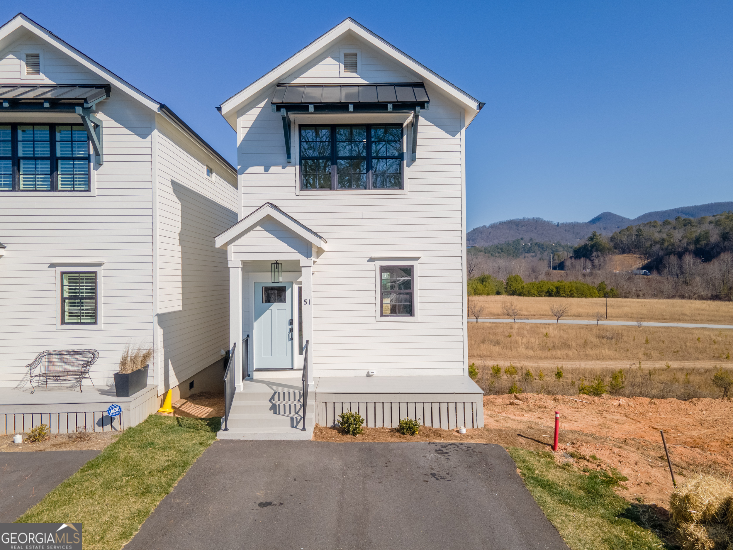 Enjoy stylish intown living in downtown Clayton in this 2 bedroom, 2.5 bath transitional farmhouse style townhome. With a "Joanna Gaines" feel, this clean lined town home features 9 plus ceilings, shiplap accents, oak flooring, modern kitchen with stainless steel appliances and tile backsplash. The open floor plan offers space for dining and lounging around the shiplap wrapped fireplace. A generous covered back deck offers space for grilling, dining and lounging while enjoying the mountains in the background. A powder room is located under the stairs for guests. Upstairs, the master bedroom offers a vaulted ceiling and en suite bath with designer tile, seamless glass shower door and double vanity. A covered deck off the master is perfect for relaxing. A guest bedroom offers a private full bath with tiled floor and shower. Enjoy easy access to casual and fine dining, boutique shopping and after hour entertainment along with all the outdoor activities of Rabun County and the surrounding mountains, rivers and lakes. Whether purchased for your own personal enjoyment or as a rental investment, this is a great opportunity to take advantage of our abundance of beautiful waterfalls and hiking trails, white water rafting, wonderful views, and coveted lakes.