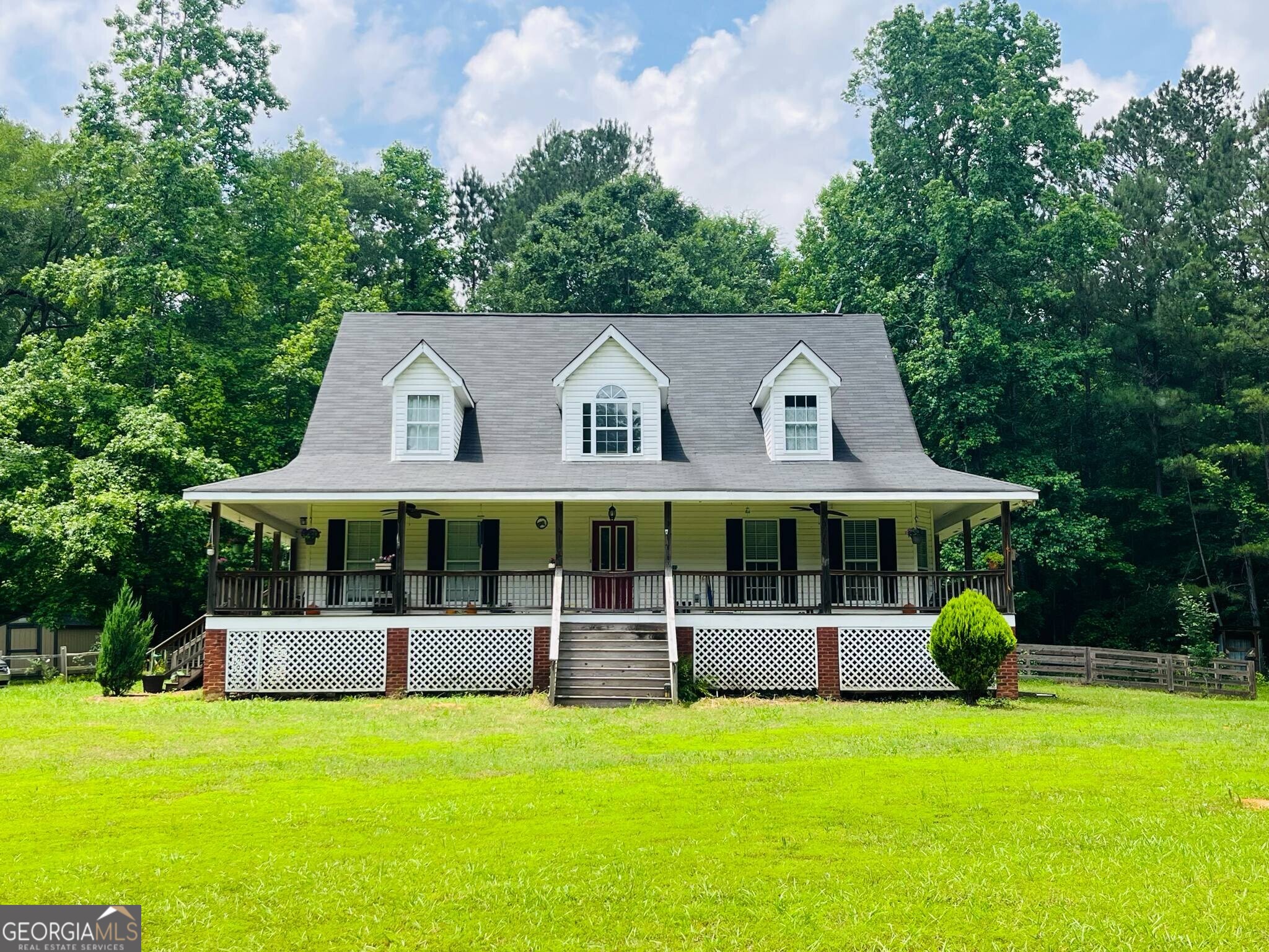 Discover this quaint and darling large FOUR BEDROOM TWO A HALF BATH CAPE COD home on 2.11 private and wooded acres in Oconee Shores in Buckhead, Morgan County, with community access to LAKE OCONEE. The neighborhood lakeside common area features a large pavilion with picnic tables and several day-use docks and boat slips and boat ramp. This home has 2800 square feet with the large master on the main. You will love the wrap-around porch that overlooks the large front yard as it sits way back from the road at the top of a long winding driveway with large oak trees and lots of woods for privacy on four sides of the property. The heart of the home is the Great Room that adjoins the kitchen and breakfast nook. The wood-burning stacked stone fireplace is the focal point of the Great Room. Enjoy your morning coffee on the back screen porch overlooking the woods or the rocking chair front porch over looking the large front yard. You will love the gorgeous honey-colored hardwood floors throughout the main floor living area. The spacious master suite is on the main level. Upstairs, you will find 3 spacious secondary bedrooms and a full bathroom. Enjoy the sunny and separate dining room while entertaining friends and family. The neighborhood lake access area is just up the street, and it is voluntary to join. It only costs $100 per year to use and has access for your boat, kayak, or paddleboards. Oconee Shores is one of the first original lake neighborhoods in Morgan County with large private lots. This property is surrounded by woods for privacy. The seller is leaving the storage shed with the property. Morgan County has award-winning schools with smaller classes and offers all the sports and advanced studies for your students. This neighborhood is located between Madison and Greensboro and is also convenient to Athens. The seller has relocated out of state and has just had the house freshly repainted and cleaned. It is ready for a new family and can close quickly. Possession is negotiable. Easy access to I-20 for a commute to Augusta or Covington or Atlanta.
