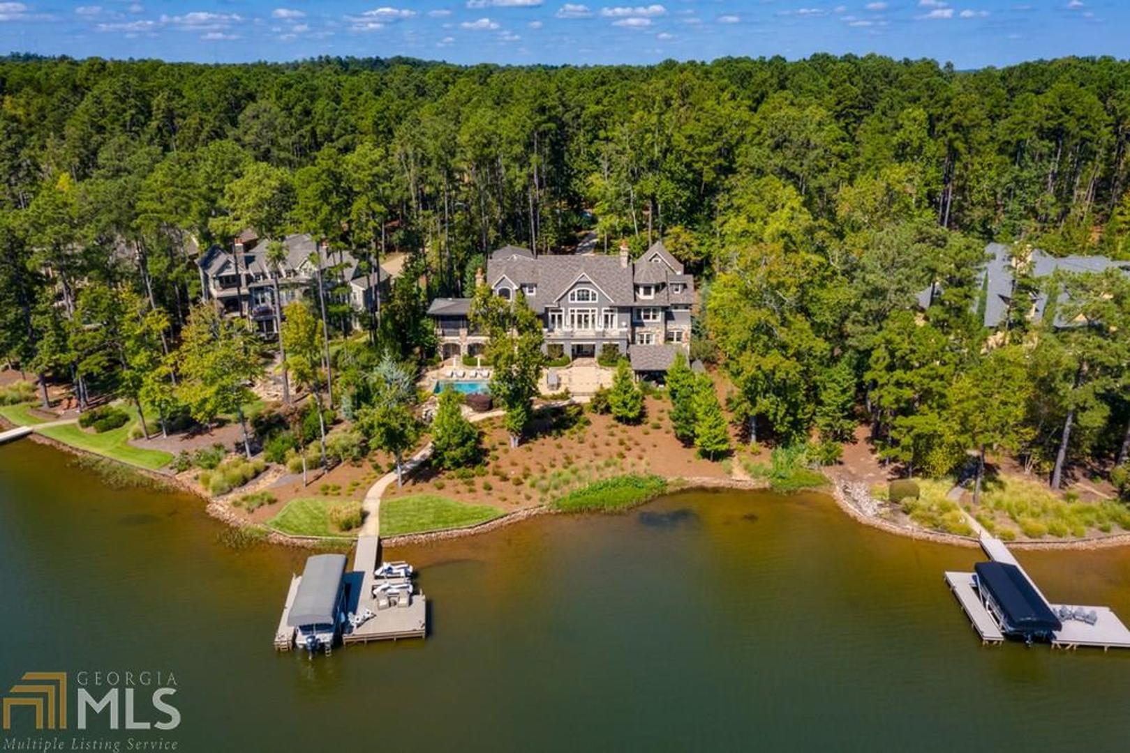 Breathtaking Lake Oconee Home situated in the exclusive gated community of Reynolds Plantation. Custom built by Dream Built and professionally decorated by Shane Meder of Black Sheep Interiors. Designed for lavish entertaining; this stunning 7 bedroom, 8 full bathroom/2 half bathroom home is as warm and inviting as it is extravagant. Greeted upon entry by an ultra impressive great room constructed with 30 ft+ high custom wooden beamed ceilings, large gourmet chefs kitchen equipped with all top of the line appliances, expansive dining area with seating for 16+, custom bunk bed room each furnished with a personal reading light & privacy curtain, surround sound home theater, temperature controlled wine cellar, and exquisitely designed 18+ seated bar. The extensive outdoor grounds yield every amenity one could desire; full-scale pristine landscaping, expansive patio with a saltwater pool & spa, upper & lower outdoor kitchens both equipped with built-in grills, and a fully covered pavilion. As you make your way down the paved pathway, cozy up to the stone fire pit or continue to the deep water dock equipped with 1 boat & 2 jet ski slips. This home has complete smart home capability controlled solely by an app. Whether home or away, at the touch of a button gain control of all lights, speaker systems, TVs, pool/spa, and security cameras. Seller is making a Club membership available.