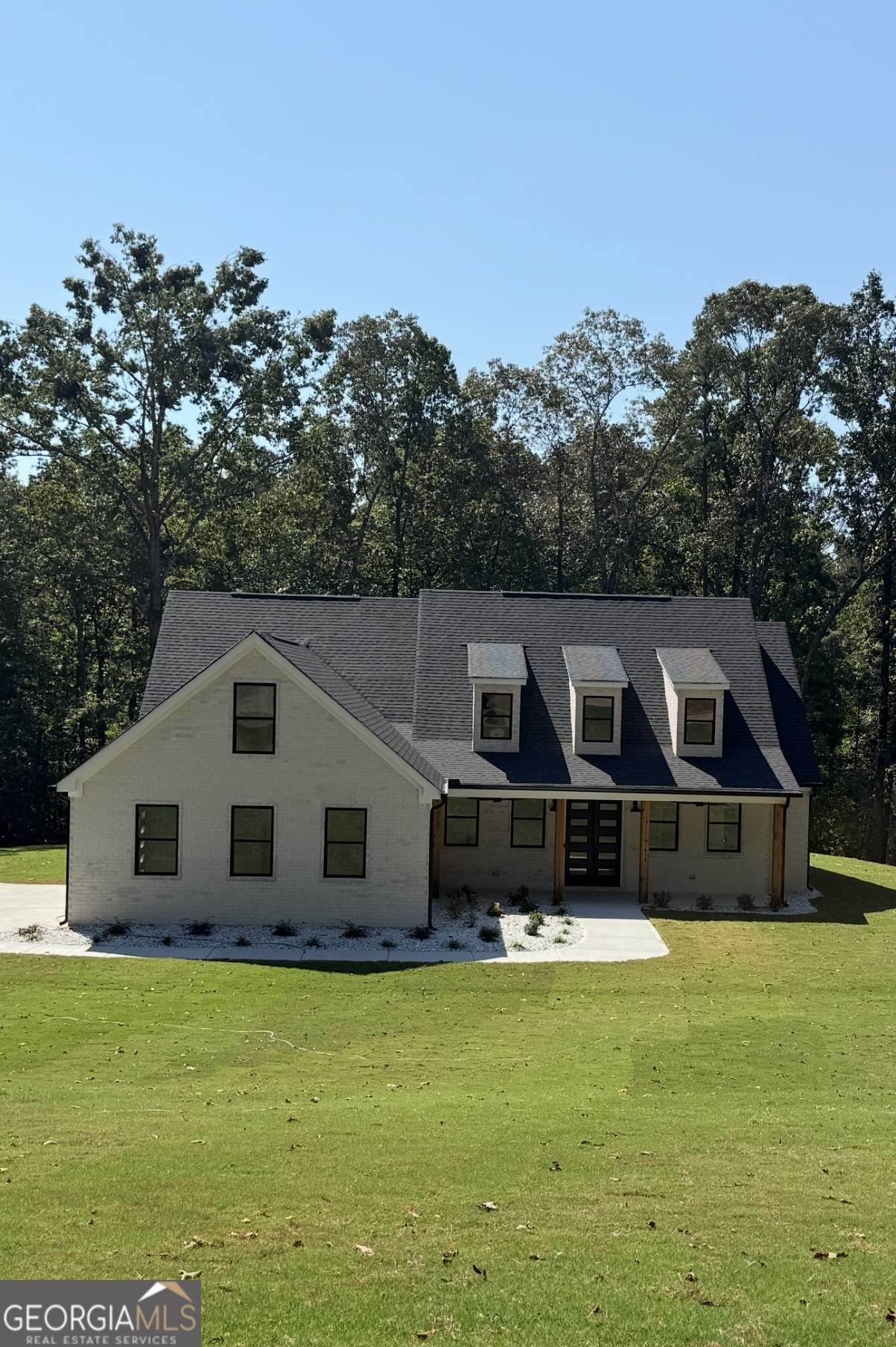 Welcome to your NEW CONSTRUCTION dream home! This exceptional four-bedroom, three-bathroom is nestled on a sprawling 2.17-acre lot, offering the perfect blend of modern comfort and natural beauty. As you step inside, you'll be immediately drawn to the inviting open living room and gourmet kitchen. All details are checked-lots of natural light, kitchen island, large pantry, stainless steel appliances, smart fridge, pot filler and tankless water heater. The designed split bedroom floor plan, featuring three spacious bedrooms on the main level, each thoughtfully placed for privacy and convenience. Ascend to the second level to discover a delightful bedroom that can also serve as a guest suite or theatre room. Entertain in style with a formal dining room that can easily be transformed into a home office or study, providing flexibility to suit your lifestyle needs. The luxurious master bedroom is a true highlight of this home, featuring a hidden built-in closet for extra privacy. Imagine unwinding by the warmth of the electric fireplace, creating a cozy atmosphere for relaxation. Now, step outside to your covered back patio, where you can enjoy the serenity of nature that surrounds you. Whether it's morning coffee or evening gatherings, this outdoor space is perfect for appreciating the beauty of your surroundings. This new construction home perfectly combines contemporary design with a peaceful setting, making it an ideal choice for those seeking a tranquil yet stylish living experience. Don't miss the opportunity to make this extraordinary property your own! Professional photos will be taken Friday and uploaded Saturday morning.