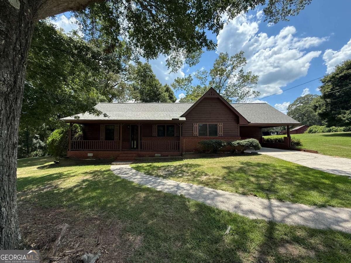 Discover the perfect blend of peaceful living and everyday convenience in this charming 2-bedroom, 1-bath home-easily adaptable to 3 bedrooms-nestled on over an acre in a desirable North Rockdale neighborhood. Just minutes from I-20 and the dining, shopping, and festivals of Old Town Conyers, this home offers the ideal location with a serene, country feel. Step inside to a spacious family room featuring a cozy brick hearth fireplace with a metal insert-perfect for cool nights. The large kitchen provides plenty of room for a dining table, abundant counter and cabinet space, and comes equipped with a brand-new oven and microwave. Central heating and air ensure year-round comfort, and a brand-new roof offers peace of mind. The oversized primary bedroom boasts a massive walk-in closet, while the flexible floor plan allows for a potential third bedroom or home office. Outside, enjoy the expansive yard, a patio perfect for relaxing or entertaining, and a handy outbuilding for storage or hobbies. The carport offers convenient covered parking and additional outdoor space. Come put your personal touch on this beautiful property and enjoy the best of Rockdale living-space, location, and charm all in one!