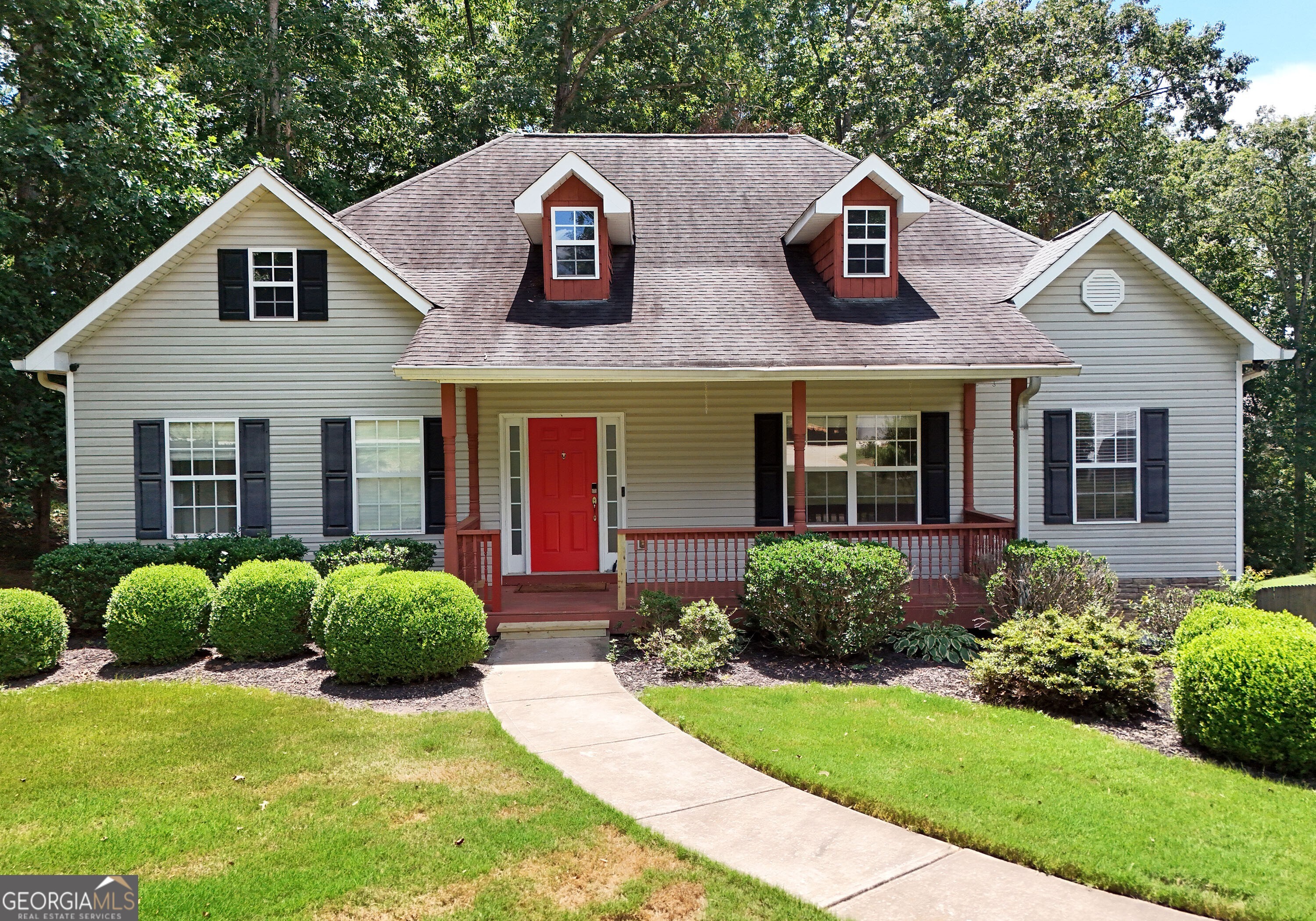Welcome to this beautifully maintained Craftsman-style ranch nestled on a private, wooded lot! This spacious 4-bedroom, 3-bath home offers the perfect combination of charm, comfort, and functionality. From the inviting front porch and bold red door to the thoughtfully designed interior, you will feel right at home. Inside, enjoy an open, airy floor plan featuring vaulted ceilings, a formal dining room with coffered ceilings and elegant wainscoting, and a cozy living area anchored by a beautiful brick fireplace. The kitchen is outfitted with rich wood cabinetry, a breakfast bar, and a clear view into the main living space, ideal for both entertaining and everyday living. The oversized primary suite provides a private retreat, while the secondary bedrooms are generously sized. Downstairs, a large family room offers the perfect space to relax or host guests, complete with an adjacent bar area, an additional bedroom, and a full bath. Step outside to the elevated back deck, perfect for morning coffee or evening gatherings with peaceful views of the serene, wooded backyard. Situated in a quiet, established neighborhood, this home offers space, style, and flexibility just minutes from local shopping and schools.