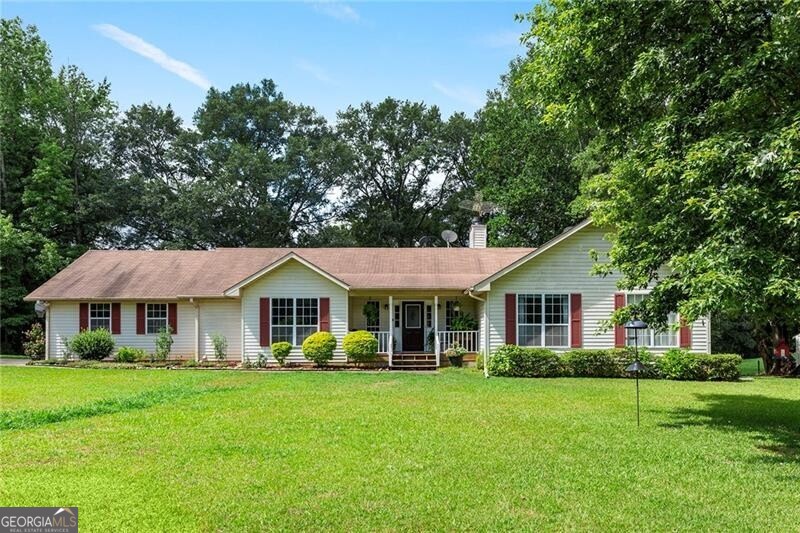 Situated amidst picturesque green pastures and framed by majestic mature oak trees, this charming ranch-style home offers a serene retreat in the heart of Chattahoochee Hill Country. Boasting a total of three fenced pastures-two in the front and a large one in the back-this property is ideal for those seeking a pastoral lifestyle. Throughout the expansive grounds, numerous fruit-bearing bushes and trees dot the landscape, adding both beauty and practicality to the setting. Inside, the main level living areas are generously proportioned, featuring soaring high ceilings in the great room and master bedroom. A glassed-in porch and adjoining full deck provide perfect vantage points for enjoying peaceful panoramic views of the surrounding pastures. The full basement is a versatile space, complete with a large media room equipped with ample storage, a full bath, and an additional office/bedroom. With its own outside entrance, the basement could easily function as a separate living unit or guest quarters, offering flexibility and privacy. Located just minutes from the vibrant Serenbe community, residents can enjoy easy access to its eclectic mix of shops, restaurants, and cultural amenities. Don't miss the opportunity to experience country living at its finest in this idyllic retreat. Schedule your visit today and envision your future in this peaceful sanctuary.