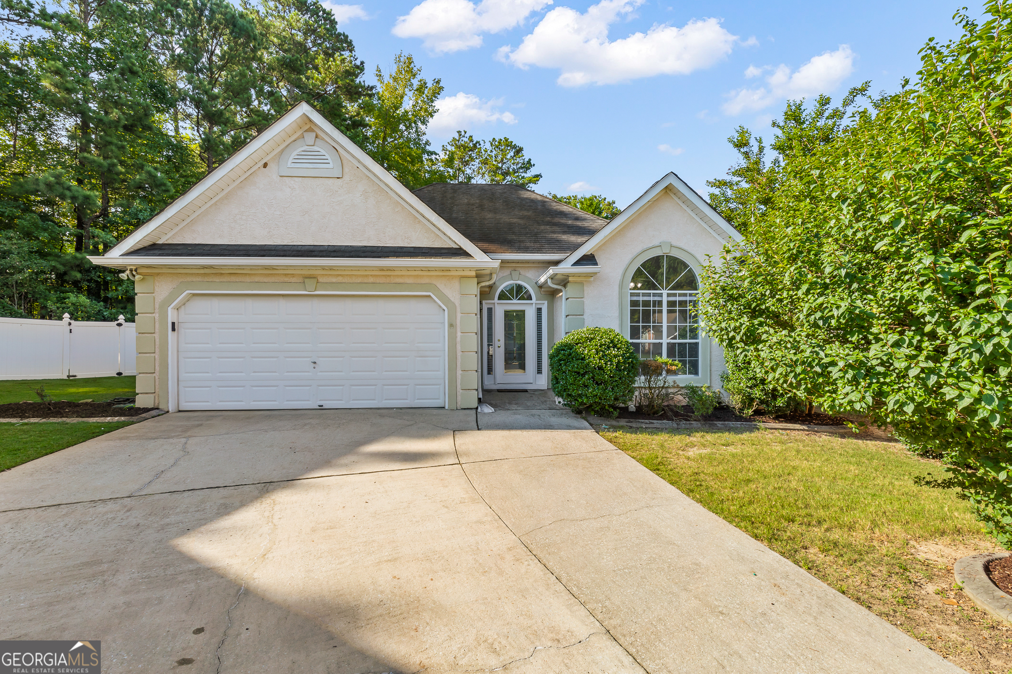 Welcome to this stunning 3-bedroom, 2-bathroom ranch home that offers the perfect blend of comfort and convenience. Located in the prestigious Starrs Mill school district, this home boasts an ideal ranch layout with a spacious primary bedroom on the main level and an abundance of natural sunlight throughout. Step into a welcoming foyer that leads you to two well-sized bedrooms at the front of the home. These rooms both have tons of natural light and are conveniently located near the secondary bathroom. This bathroom will feature newly updated cabinet fronts prior to closing. All bedrooms are equipped with brand-new carpet, large closets, and ample natural light. One bedroom even features a stunning vaulted ceiling, adding a unique touch to the space. The spacious primary bedroom is tucked away for privacy, offering a serene retreat. It boasts large windows that invite plenty of sunlight and an ensuite bathroom with double vanities, a separate tile shower, a soaking tub, and a huge walk-in closet-perfect for your storage needs. The oversized great room features a vaulted ceiling and a cozy gas log fireplace-ideal for family gatherings or quiet relaxation. The adjoining dining room offers convenience and easy access to the kitchen, making entertaining a breeze. The kitchen is complete with brand-new cabinet doors and drawers with sleek modern pulls, a gas stove, built-in microwave, ample countertop space, and a pantry for additional storage. The open layout makes it perfect for cooking while still being part of the action in the great room. The dedicated laundry room will include updated cabinet fronts prior to closing and features ample space for your washer and dryer. Best of all, the washer and dryer are included with the home, making your move-in easy and hassle-free. The two-car garage offers one step entry into the kitchen, adding convenience and ease to your daily routine. Step outside to a cozy patio overlooking a partially private backyard. The space is perfect for relaxing or adding your personal touches with flowers or outdoor furniture. This home is part of a well-maintained HOA community that handles lawn care and trash pickup, making for low-maintenance living. Ideally located in a quiet, desirable neighborhood within the Starrs Mill school district, this home is perfect for anyone looking for a peaceful retreat with easy access to local amenities. Don't Miss Out! This charming ranch home won't last long. Schedule your showing today before it's gone! All cabinets and drawers fronts will be new, waiting on the vendor to finish completing. Kitchen, both bathrooms and laundry room cabinets will be completed.
