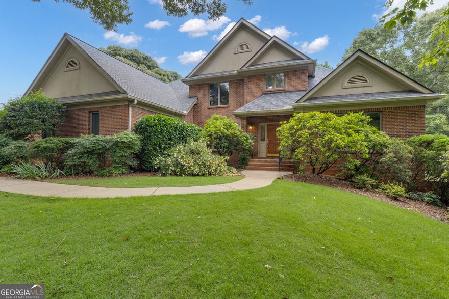 Tucked into the tree-lined serenity of Peachtree City's sought-after Kedron Hills, this extraordinary estate blends classic craftsmanship with comfort. With over 6,300 square feet of well-appointed living space and access to top-tier amenities-including a junior Olympic-sized pool, playground, and basketball court-this is where luxury living meets lifestyle ease. Enjoy the convenience of 100+ miles of golf cart paths that connect you to restaurants, shopping, and award-winning McIntosh High School, with close proximity to I-85, Hartsfield-Jackson Airport, Trilith Studios, and the US Soccer Training Facility.  Built with integrity in 1989 and thoughtfully enhanced throughout, this stately home invites you in with a warm, welcoming presence. Step through the front door and into a two-story foyer that opens to a graceful formal dining room, ideal for hosting gatherings with room to comfortably seat eight. Hardwood, tile, and carpet flow across the main floor, leading you into a grand great room anchored by a gas-start fireplace, soaring ceilings, and custom built-ins-perfect for quiet evenings or entertaining in style.  The kitchen, the true heart of the home, features top-of-the-line built cabinetry and is easily updated to meet modern design preferences. A sunlit breakfast area offers a peaceful spot for morning coffee, overlooking the lush, private backyard. Just off the kitchen, a light-filled sunroom with sliding doors seamlessly connects indoor and outdoor living, opening to a spacious deck shaded by mature trees and a retractable awning-an ideal retreat for alfresco dining or weekend relaxation.  With 5 spacious ensuite bedrooms-two on the main level, two upstairs, and one in the basement-there's room for multigenerational living, guests, or a growing household. Two primary suites on the main offer tranquil escapes, each with their own bathrooms. Every bedroom is thoughtfully designed to ensure privacy and comfort.  The fully finished terrace level expands your living options with a recreation room, storm shelter/storage area, oversized workshop, and dedicated golf cart garage. Additional highlights include an 80-gallon recirculating water heater, dual hot water heaters, surround sound throughout the kitchen, great room, lower level, and outdoor spaces, central vacuum system, and a security system for peace of mind.  Practical upgrades are everywhere: a new roof and furnace (2024), energy-efficient e-glass windows with tight seals, extra insulation in the attic and walls, a leaf filter system with lifetime guarantee, sprinkler systems front and back, and a renewed lifetime termite bond with Massey. The home was built with quality construction in mind-poured concrete basement walls, insulated exteriors, and joists spaced 18" apart for added structural integrity.  The oversized laundry room, just off the kitchen, includes an ironing station, utility sink, and abundant built-ins for seamless functionality. A spacious three-car garage adds convenience and storage, while the fully fenced backyard creates a quiet sanctuary for outdoor living and play.  This home is more than just a place to live-it's an experience. A blend of thoughtful design, timeless architecture, and premier location makes this property a rare find in one of Peachtree City's most desirable communities.