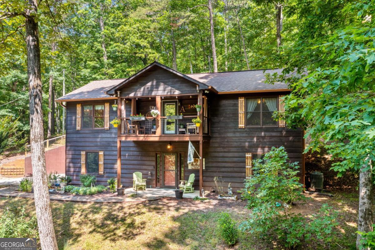 Perched in the tranquil, wooded surroundings of the amenity-packed Coosawattee River Resort, this whimsical home offers a perfect blend of comfort, nature & convenience. Just around the corner from the community's rec center, enjoy access to an Olympic-sized indoor pool, fitness & game rooms & tennis/pickleball courts, all while tucked away in a private spot. Set on a combined double lot with an oversized one-car garage there is ample space for storage & vehicles. The upper level features a thoughtfully laid-out floor plan, with the kitchen flowing seamlessly into the dining & living areas. Enjoy the hickory cabinets, stainless steel appliances & the convenience of a walk-in pantry. The living room's vaulted beadboard ceiling adds a touch of elegance, while the mix of beadboard wainscoting & drywall gives the space a welcoming, rustic charm. A covered porch off the main living area lets you feel like you're in a treehouse, surrounded by the beauty & privacy of the woods. The relaxing master suite features a large walk-in closet & a beautiful en-suite bath complete with tiled walk-in shower w/glass door & double vanity. A 2nd bedroom & full bath w/a tub/shower combo are conveniently located off the main hallway. This level also has a secondary entrance leading to a deck perfect for grilling or enjoying the adjacent garden space. Downstairs, you'll find a generous living area with its own entrance, offering flexibility for use as a guest suite, game room, or media space. A half bath, laundry area & workshop space are also on this level, perfect for hobbies or extra storage. With no neighbors in sight, the peaceful wooded setting provides the ultimate escape, where you can enjoy the quiet & watch deer roam freely through your yard. The community offers even more activities w/3 pools, riverside parks, fishing pond & plenty of events like Pickin' on the Porch summer concerts. Come explore this whimsical retreat & make it your own private oasis!
