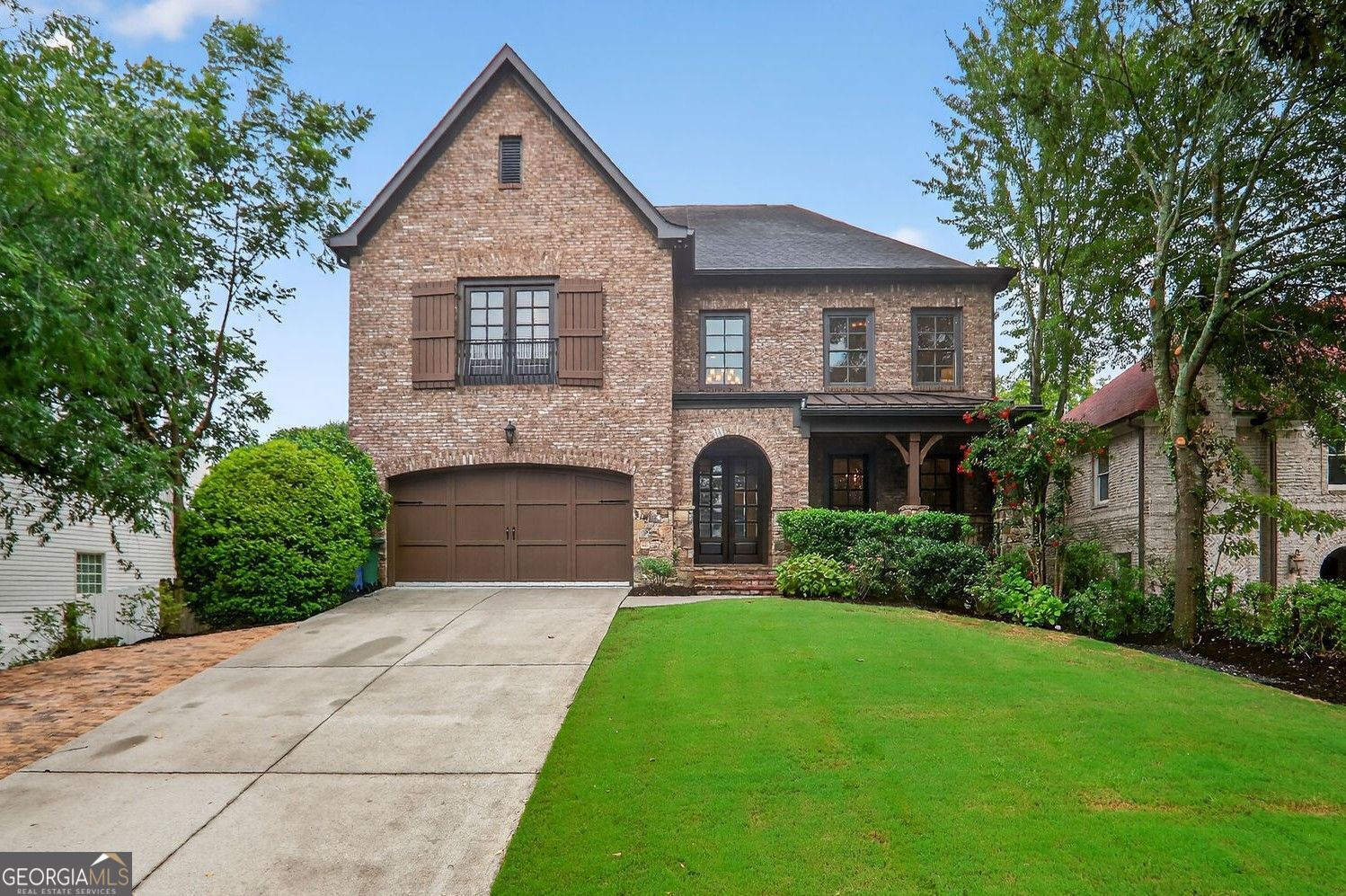 Classic style blends with modern functionality in this brick and stone home in Ashford Park situated walking distance to Georgian Hills Park and the trails of Skyland Preserve. Charming front porch, welcoming two-story foyer and an open floor plan designed for everyday living and entertaining. The renovated kitchen is the heart of the home, featuring custom inset cabinetry, quartz countertops, stainless steel appliances including both a dishwasher and sub zero refrigerator with cabinet matching panel, and great counter seating. It flows seamlessly into a bright breakfast area, a cozy keeping room with upgraded lighting and trim, and a fireside living room with built-ins and recessed lighting. Step outside to a screened porch, perfect for cool nights by the fire, that overlooks a large, flat, walk-out backyard with beautiful sod, irrigation and privacy. An additional open-air deck makes grilling a breeze. The main level also includes a separate office nook, mudroom entry from the garage, and a full guest suite. Upstairs, the expansive owner's suite offers a sitting room, coffered ceilings, custom closets, and a luxurious bath with a multi-head walk-in shower, soaking tub, double vanity, and tons of built-in storage. A second, private laundry room can be a functional upgrade or considerable additional closet space. Three additional bedrooms each with a full bath, and a laundry room off the upper hall with counter, cabinets and a wash sink. The finished basement is a true showstopper with a game/media room, bar/kitchenette, full bath, and three versatile rooms for a gym, guest space, hobbies, or more. A rare opportunity to own a well-appointed home in one of Brookhaven's most sought-after neighborhoods.