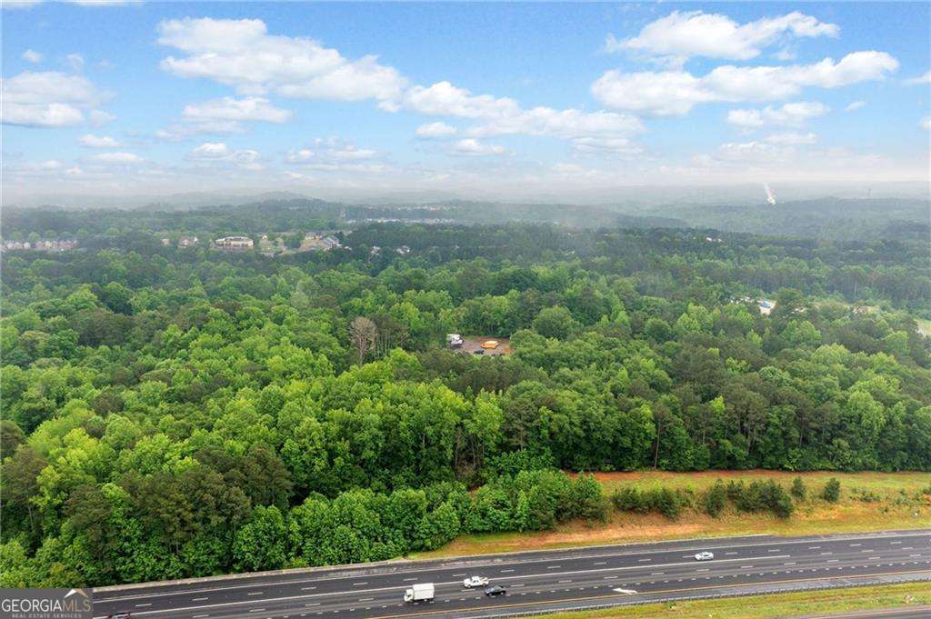 Prime 27.2-Acre Investment Opportunity - Exceptional Commercial Development Potential. Strategically located near the intersection of Sixes Road and Main Street, this 27.2-acre property offers a rare opportunity for commercial development in fast-growing Cherokee County. With approximately 2,529 feet of road frontage along North Rope Mill Road and 376 feet along I-575 on Tract A (7 acres), this property boasts outstanding visibility and accessibility. Currently zoned Agricultural, the land is identified for Commercial Development under the county's future land use plan-making it an ideal site for a wide range of investment projects. Key Highlights: Just 1.4 miles to WellStar Cherokee Health Park. Only 0.7 miles to Home Depot, 0.9 miles to Kroger Grocery and Pharmacy. Approximately 4.7 miles to Downtown Woodstock, GA, 3.1 miles to Holly Springs, GA. Walk to Olde Rope Mill Park. Excellent topography with no floodplain. High traffic counts and strong area growth. This parcel is being sold as-is. There is an existing tenant in the house-please do not disturb. Showings by appointment only. Whether you're an experienced developer or a savvy investor looking for a foothold in one of Cherokee County's most dynamic corridors, this property presents unmatched potential.