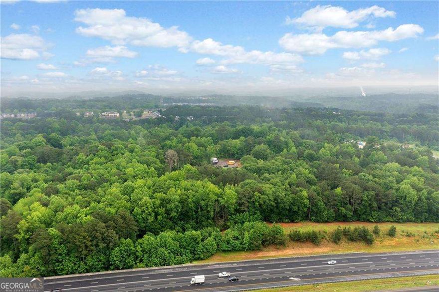 Prime 27.2-Acre Investment Opportunity - Exceptional Commercial Development Potential. Strategically located near the intersection of Sixes Road and Main Street, this 27.2-acre property offers a rare opportunity for commercial development in fast-growing Cherokee County. With approximately 2,529 feet of road frontage along North Rope Mill Road and 376 feet along I-575 on Tract A (7 acres), this property boasts outstanding visibility and accessibility. Currently zoned Agricultural, the land is identified for Commercial Development under the county's future land use plan-making it an ideal site for a wide range of investment projects. Key Highlights: Just 1.4 miles to WellStar Cherokee Health Park. Only 0.7 miles to Home Depot, 0.9 miles to Kroger Grocery and Pharmacy. Approximately 4.7 miles to Downtown Woodstock, GA, 3.1 miles to Holly Springs, GA.  Walk to Olde Rope Mill Park. Excellent topography with no floodplain. High traffic counts and strong area growth. This parcel is being sold as-is. There is an existing tenant in the house-please do not disturb. Showings by appointment only. Whether you're an experienced developer or a savvy investor looking for a foothold in one of Cherokee County's most dynamic corridors, this property presents unmatched potential.