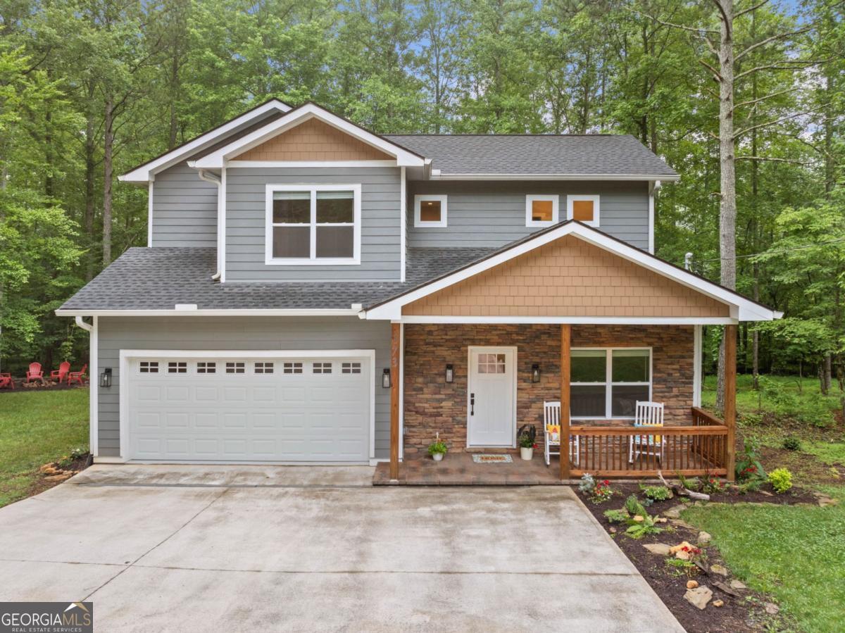 Welcome to this beautifully maintained, like-new home in the sought-after Coosawattee River Resort. Located close to the gate on all paved roads & situated on a level lot, the home offers a concrete driveway, 2-car garage, and firepit area perfect for evenings under the stars. Breeze through the charming front porch to a thoughtfully designed interior where comfort meets elegance. Just off the foyer, you'll find a versatile office that could serve as a 4th bedroom if needed. A convenient half bath & spacious laundry room with folding counter with a sink, and a closet add to the home's functionality. Don't miss the under-stairs closet for extra storage! The open-concept main living area is a true showstopper with soaring vaulted ceilings finished in tongue & groove wood, adding a warm mountain feel, plus a floor-to-ceiling stone wood-burning fireplace. Oversized windows flood the space with natural light and offer serene views of the wooded private backyard. The chef's dream kitchen features abundant cabinetry, gleaming granite countertops, an island, built-in coffee bar with wine fridge, and bright, modern finishes. The adjacent dining area opens to a large covered back porch where you can relax and take in the peaceful setting while watching deer roam. Upstairs, the expansive master suite offers vaulted ceilings, a large walk-in closet, and luxurious ensuite bath with granite double vanity, private water closet & stunning, tiled walk-in shower with glass door. Two additional bedroom suites each with their own beautifully finished full ensuite bathrooms offer comfort and privacy for family or guests. With a harmonious blend of wood and drywall finishes throughout, Hardie board siding for easy maintenance, and all the high-end features you'd expect, this property is the perfect combination of style, function, and location. The community has top-notch amenities including: 3 pools, Rec Center with gym & game room, riverfront parks, resident activities, and more. This home offers the perfect combination of luxury, function and community in one of North Georgia's top gated resorts.