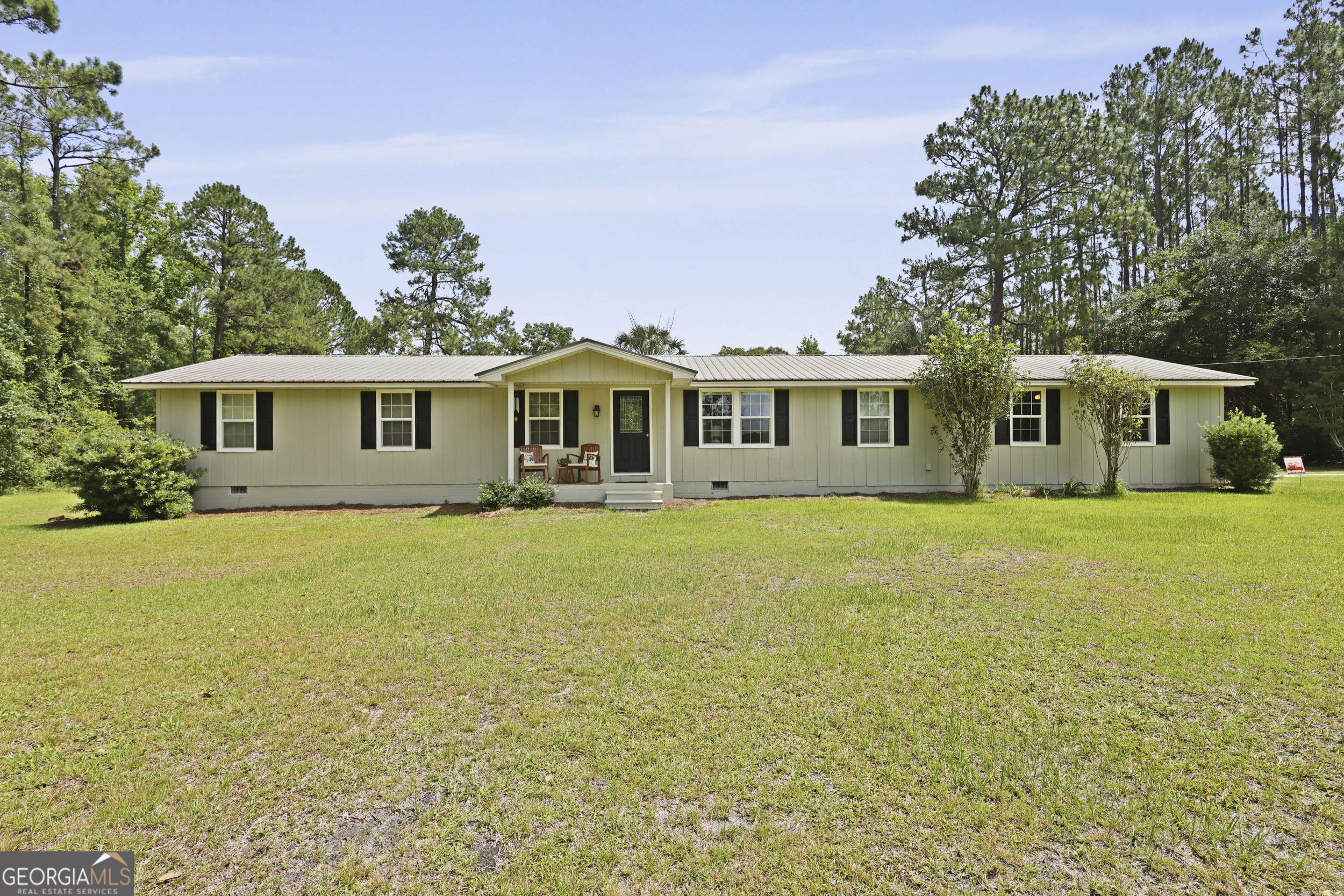 Welcome to this beautifully updated 3-bedroom, 2-bath ranch-style home nestled on 4.17 unrestricted acres in the county. With 1,488 sq ft of living space, this home offers a thoughtful layout including a bonus room-perfect for a nursery, office, or playroom-right off the primary suite. Inside, you'll find modern updates throughout: new appliances, new flooring, solid surface countertops, and a stylish step-in tile shower. The home has been well cared for and is both inviting and functional. Step outside to enjoy the charm of the covered porches, including a partially screened back deck that's ideal for relaxing or entertaining. There's even an outdoor sink with hot and cold water for convenience. A newly added metal building, shed, greenhouse, and a 2-car garage provide ample storage for tools, hobbies, or equipment. If you're looking for peaceful country living with room to breathe and no restrictions, this property checks all the boxes.