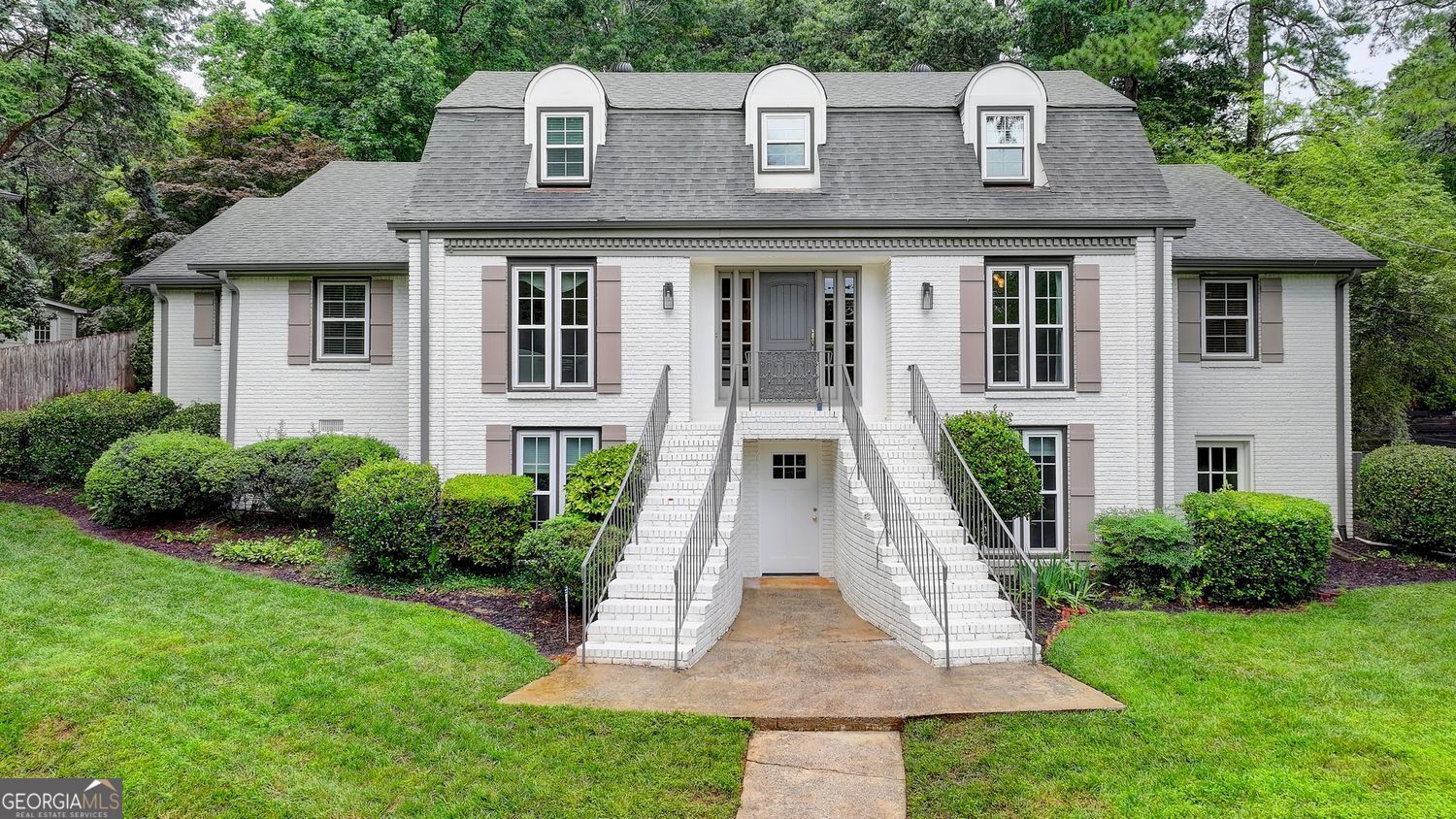 Welcome to your next Dunwoody home! As you step into the entryway, you are greeted by an ambiance that resonates with elegance and sophistication, and an amazing open floor plan! The spacious layout is designed with both functionality and aesthetic appeal in mind, creating an atmosphere that is perfect for both relaxing evenings and family gatherings. Recent upgrades include a freshly painted exterior, charming new shutters, and brand-new windows throughout enhancing both curb appeal and energy efficiency. Inside, large windows elegantly frame the views, allowing natural light to flood the interiors and highlighting the tasteful decor. The living area serves as a perfect focal point, with fantastic custom-built ins, offering a cozy retreat complete with ample seating arrangements. Flowing seamlessly into the dining space, this area is designed for both intimate dinners and festive celebrations. Adjacent to the dining area, you'll find an updated kitchen that is not only a culinary dream but also a central hub for family and friends. Equipped with modern appliances, upgraded finishes, and abundant counter space, it's ideal for those who love to cook and entertain. A highlight of the main level is the stunning sunroom, thoughtfully renovated to serve as a serene, light-filled space perfect for morning coffee or an afternoon read. On the main level, you'll also find a dedicated home office, perfect for remote work, study, or a quiet creative space. Additionally, the primary suite and a guest bedroom are conveniently located on the main level. The property boasts several bedrooms, each designed to provide a peaceful sanctuary. The primary suite features a fully renovated bathroom with double vanities, offering a spa-like experience perfect for unwinding after a long day. The fully finished basement offers even more versatile living space-ideal for a home theater, game room, gym, or guest suite. Outside, enjoy beautifully landscaped grounds and a walk-out backyard that leads to a custom paver patio, perfect for entertaining or enjoying quiet evenings under the stars. With its extensive list of recent upgrades and an unmistakable charm that permeates every corner, this beautifully enhanced residence stands ready to be your next cherished home. A true gem-don't miss your chance to make it yours.