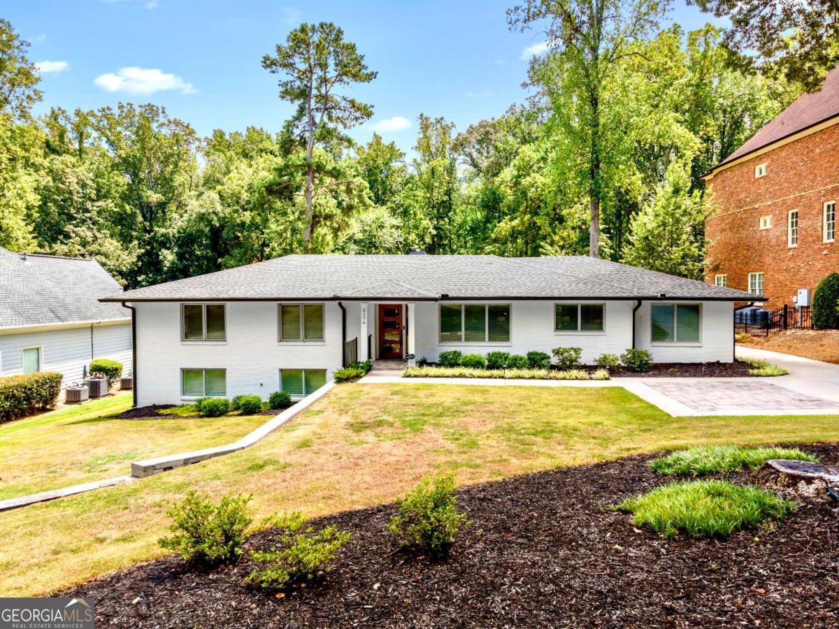 Beautifully remodeled and thoughtfully designed, this spacious 5-bedroom, 3-bath brick ranch offers modern comfort, timeless style, and exceptional indoor-outdoor living in one of Smyrna's most desirable neighborhoods. The open-concept layout is filled with natural light and features white oak hardwood floors and designer finishes throughout. The chef's kitchen is a true centerpiece, complete with a 48" KitchenAid gas range, double convection ovens, quartz countertops, pot filler, microwave drawer, oversized farm sink, custom cabinetry, and a large walk-in pantry. The primary suite overlooks the private backyard and includes a custom walk-in closet and spa-style ensuite with rain shower, dual vanities, and updated LVP flooring. Additional main-level highlights include a dedicated home office with heated stone floors, a stylish mudroom, and two more bedrooms. The finished terrace level adds a large rec room, two additional bedrooms, a full bath, laundry room, and generous storage. Outside, enjoy a covered patio with a fireplace-perfect for entertaining or unwinding-surrounded by mature trees, lush landscaping, and a seven-zone irrigation system. Additional features include spray foam insulation, tankless water heater with recirculation, high-efficiency HVAC with advanced filtration, and Wi-Fi-enabled thermostats. Zoned for Teasley Elementary and minutes from The Battery, Vinings Jubilee, Smyrna Market Village, and major highways, this home blends comfort, style, and location into a truly special offering.
