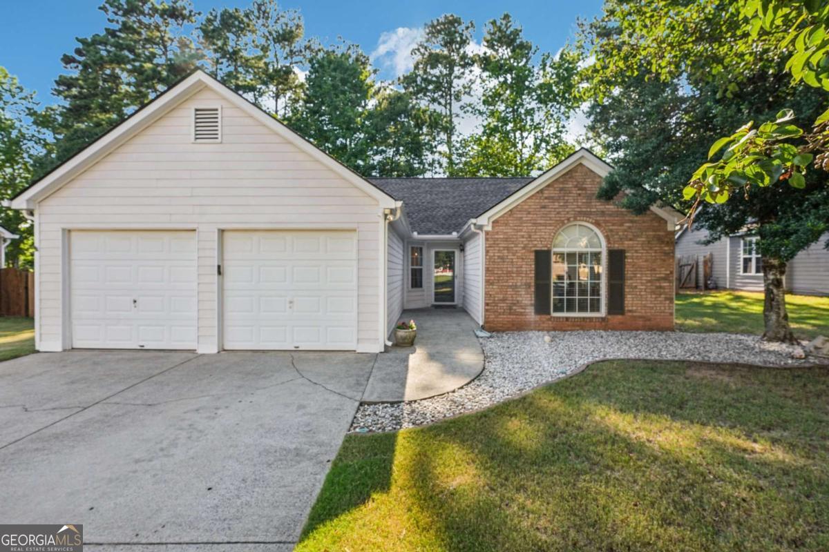 Welcome to this beautifully maintained single-story charming ranch home, ideally located in the vibrant and amenity-rich community of Lake Park. Step inside to find stunning, low-maintenance laminate wood flooring that flows seamlessly through the main living areas, combining both style and durability. The bright and open-concept living room features a cozy fireplace and effortlessly connects to the dining area, which offers views of the private, wooded backyard. The spacious kitchen is perfect for both daily living and entertaining, complete with a center island, breakfast bar, ample cabinetry and counter space, and stainless steel appliances-including a brand-new dishwasher and oven. For ultimate privacy, the primary suite is tucked away and features a vaulted ceiling and a private en-suite bath. On the opposite side of the home, you'll find two generously sized secondary bedrooms along with an updated full hall bath boasting a new tub/shower combo, modern vanity, and updated flooring. Step outside to a peaceful backyard with a patio slab that's ideal for grilling, relaxing, or entertaining-all backing to wooded views for added privacy. Additional upgrades include: Stylish modern light fixtures, Newer A/C unit and water heater. Located just minutes from Downtown Acworth, Kennesaw State University, and Logan Farm Park, with easy access to I-75, Hwy 92, and Cobb Pkwy/41. Enjoy nearby Lake Allatoona, Lake Acworth, Acworth Beach, and a variety of shopping, entertainment and dining options. The Lake Park community offers fantastic amenities including a pool, tennis courts, basketball, volleyball, and a pavilion-all with an incredibly low HOA fee! This move-in ready gem perfectly blends peaceful living with unbeatable convenience. Don't miss your opportunity to call this beautiful home your own! Schedule your private tour today!