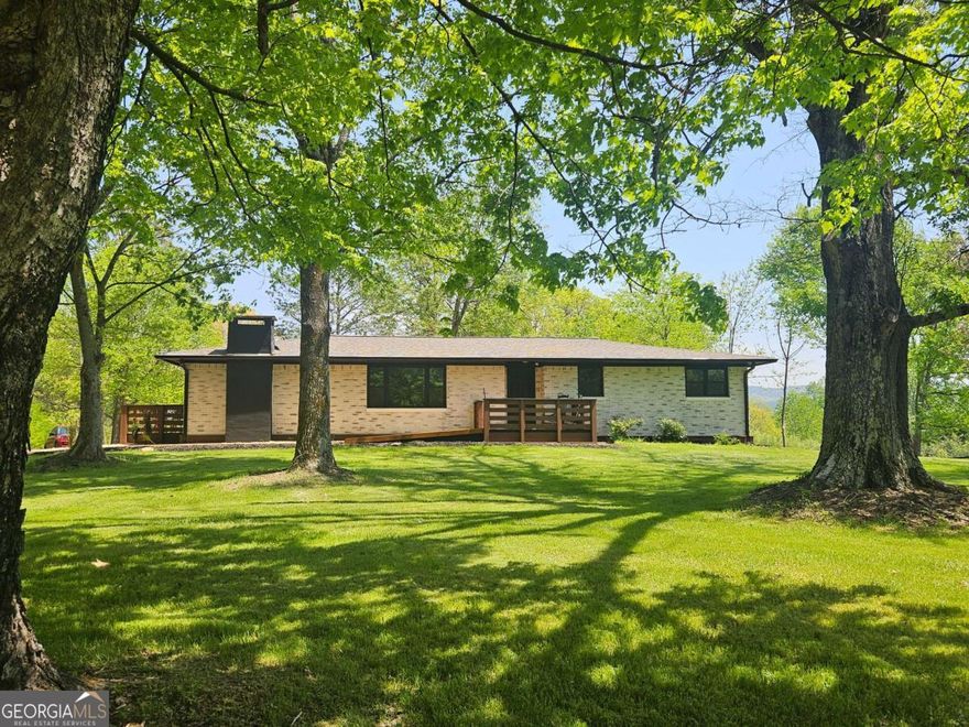 A Dream Home with Modern Amenities and Scenic Views.   Nestled in picturesque west Pickens County, this exquisite property is ideally located just 15 minutes from Publix.  While the original home was built in 1968, the only original features are the exterior brick and the roof trusses (and they have been strengthened).  This beautifully remodeled mid-century home sits on a sprawling 1.5-acre quiet corner lot, surrounded by majestic old-growth oak trees, providing a serene park-like setting. The house has been completely revamped, and there is not a single step anywhere inside or outside of the house. The main hallway inside is extra wide, and the master bathroom has a walk-in shower.  Every inch of the plumbing and wiring has been replaced, 12-gage wiring has been used throughout the house, providing peace of mind and functionality for the new homeowners. New solid core doors were installed all through the home. One of the standout features of this property is the long-distance views of the mountains. The expansive double-entry driveway is all brand-new concrete without a single crack anywhere.  The kitchen boasts stunning quartz countertops that not only enhance the beauty of the space but also offer durability and low maintenance. Equipped with top-of-the-line brand-new appliances including Bosh Microwave and Dish Washer, LG Refrigerator. this kitchen is a chef's paradise, making cooking a delightful experience. The kitchen features custom high-end white cabinets that add both style and ample storage space. Brand new Anderson Windows have been installed throughout. Both bathrooms in the house are completely remodeled with modern fixtures and finishes, offering two spa-like retreats within the home.  This property also includes a remodeled detached garage equipped with an electric car outlet and workshop-style electrical outlets all around the perimeter.  This home is a perfect blend of luxury, comfort, and natural beauty, making it an ideal choice for those seeking a high-end lifestyle in west Pickens County.