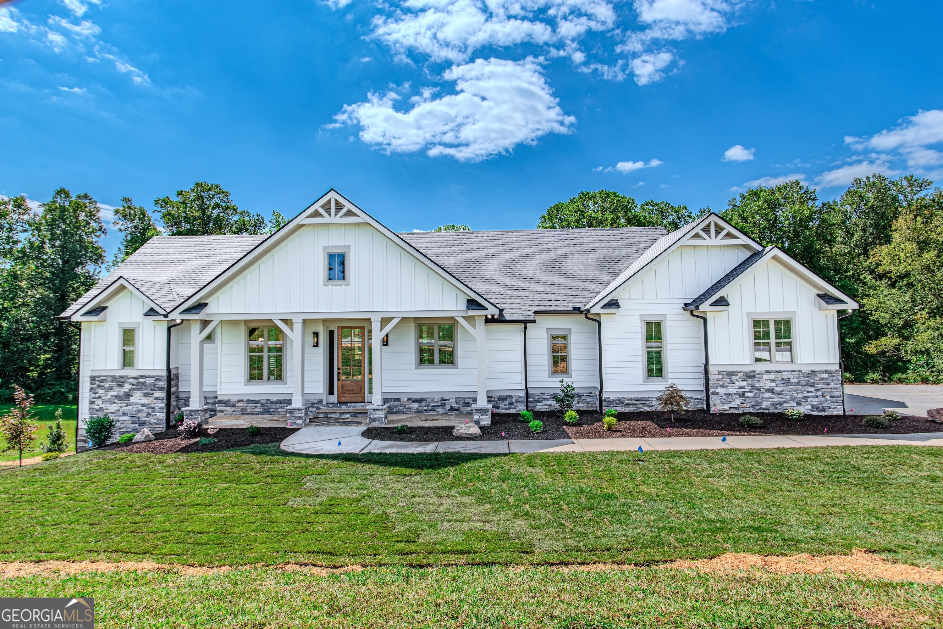 Recently completed by TS Family Homes, this 4BR / 3BA, 3,200-square-foot modern craftsman combines timeless curb appeal with modern functionality in one of North Georgia's most sought-after gated golf communities. Set on a private creek-side lot, the home offers 1,712 square feet on the main level and an additional 1,488 square feet in the finished basement, providing flexible space for family, guests, or hobbies. The open-concept main level is anchored by a stunning stone fireplace and a gourmet kitchen that makes entertaining effortless. There is no such thing as "builder grade" with TS Family Homes; every detail is elevated. The kitchen features custom soft-close cabinetry, granite countertops, high-end stainless steel appliances, and a large island perfect for gatherings. Bathrooms are finished with granite countertops and custom tile showers, with tile extending all the way to the 10-foot ceilings for a truly luxurious feel. Even the interior solid-wood doors are 8 feet high, enhancing the home's sense of space. Additional features include a laundry room, 2-car garage, and covered porches to enjoy the peaceful surroundings. Craftsman-style architecture, distinctive stone accents, and quality finishes inside and out create a welcoming, enduring design. The Owen Glen community offers resort-style amenities, including a clubhouse, swimming pool, tennis and pickleball courts, a fitness center, walking trails, and the acclaimed Old Union Golf Course with a Pro Shop. Located just minutes from downtown Blairsville, Lake Nottely, and the Chattahoochee National Forest, residents enjoy the perfect blend of recreation, relaxation, and community. Don't miss this rare opportunity to own a brand-new modern craftsman in an amenity-rich, gated setting. Secure your place in Owen Glen today and experience exceptional construction quality paired with timeless design.