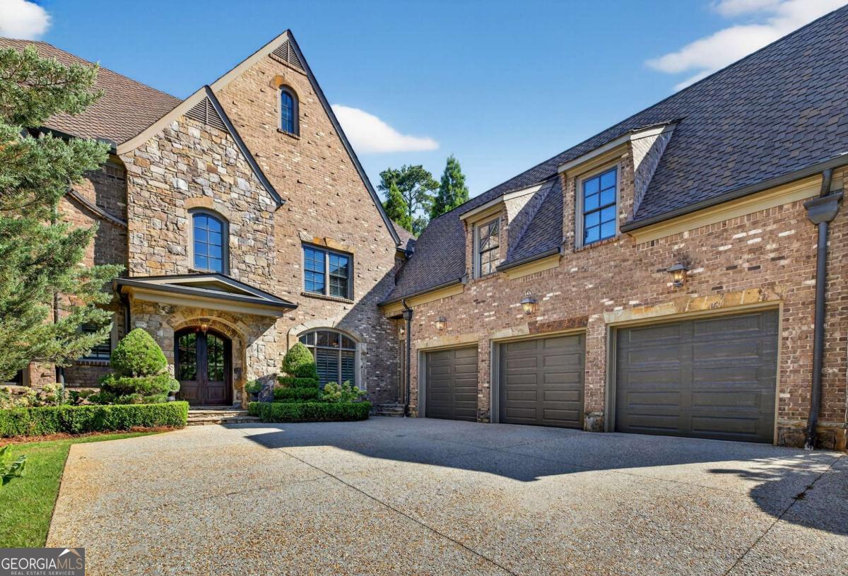 Stunning North Buckhead Residence in The Park at Brookhaven! This exquisite home offers an unmatched blend of elegance, comfort, and convenience, just minutes from the heart of Buckhead. Enjoy proximity to Phipps Plaza, Lenox Mall, Capital City Club, Nancy Creek Park, renowned restaurants, and top medical centers including Emory Saint Joseph and Northside hospitals. Designed with exceptional craftsmanship and attention to detail, this residence features four-sided brick construction and soaring ceilings on all three levels that create a grand and open atmosphere. The main-level primary suite is a private retreat, complete with a renovated spa-like bath and an oversized dressing suite. A two-story foyer opens to a sophisticated wood-paneled office, perfect for work or meetings, and a formal dining room with butler's pantry. The chef's kitchen is a true showpiece, featuring an oversized island with prep sink, Sub-Zero refrigerator, 48" Viking range with six burners and double ovens, and a dedicated bar area with wine cooler, dishwasher, and additional refrigerator. The kitchen flows seamlessly into a dramatic morning room with vaulted beamed ceiling and stone fireplace. Accordion/bi-fold doors open to a covered porch with fireplace, automatic screen, and slate flooring, ideal for year-round entertaining overlooking the private backyard. Additional highlights on the main level include a mudroom, pocket office, laundry room, and two half baths. The upper level offers spacious en-suite bedrooms, a secondary dressing suite, an additional laundry room, and an expansive Au Pair Suite providing privacy and comfort. The terrace level is designed for entertaining with a custom bar, wine wall with cabinetry and shelving, and additional unfinished space for future build-out or storage. With four fireplaces, two laundry rooms, extensive storage, and refined finishes throughout, this home offers the perfect balance of luxury and livability in one of Buckhead's most desirable neighborhoods.