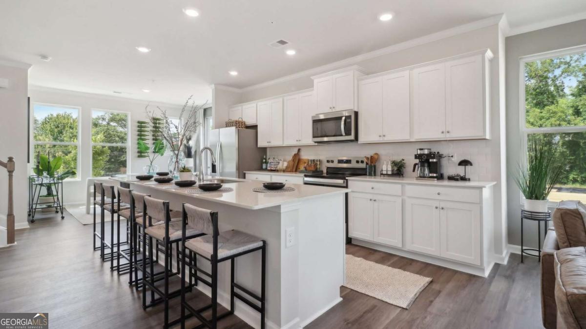 New beautifully crafted easy living three story "Asbury 1" floor plan in the award winning Hapeville community 10 minutes from Hartfield Jackson ATL Airport. The Asbury 1 floorplan offers three bedrooms each featuring en-suit bathrooms, a half bath on the second level totaling 3.5 baths in total. The ground level includes a two car garage, a nice sized bedroom with an en-suit bath. The second level includes an open concept layout with kitchen overlooking dining and family room. Revwood flooring throughout the main, chef-inspired kitchen offers a large island with quartz countertops and stainless-steel appliances. The upstairs features two generously sized bedrooms along with a washer & dryer area, luxury vinyl stairs throughout along with high ceilings. In addition to the fantastic location, home owners will enjoy the close proximity to a selection of bars and restaurants in the Hapeville location with a short 15 minute commute to midtown Atlanta.