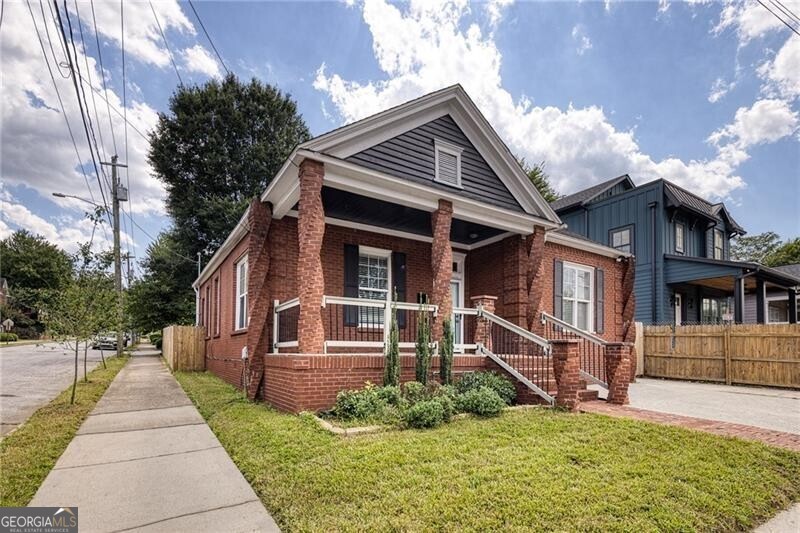 It's a BOGO! Charming all-brick home featuring 3 bedrooms and 2 full bathrooms in the main residence and a bonus guest house/studio apartment ideal for Airbnb, long-term rental, home office, or creative space. The main home boasts a brand-new kitchen with stainless steel appliances, shaker cabinetry, island, and pantry. Enjoy the open floor plan, high ceilings, living room with fireplace, and hardwood floors throughout. Private, fenced, level backyard on a corner lot. Located in the fantastic Summerhill neighborhood, it's just a short walk to the new Publix, fine dining, and the exciting Hank Aaron development with shops and restaurants