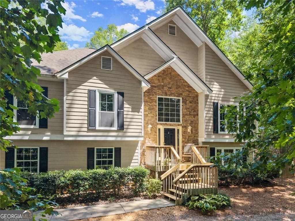 Welcome home to this spacious 4-bedroom, 3-bath split foyer nestled on 1.11 private acres. Step into a grand entryway leading to the family room with soaring cathedral ceilings and a cozy wood-burning fireplace with gas starter. The kitchen features custom cabinetry, solid surface countertops, stainless steel appliances, and a sunny breakfast nook, with a formal dining room just off the kitchen-perfect for entertaining. Gleaming real hardwood floors run throughout the main level. The primary suite offers soft carpet underfoot and a completely updated ensuite with a soaking tub, separate tiled shower, tile floors, and a double vanity. Two additional bedrooms and a full bath complete the main floor. The home also features all-new double pane windows, providing enhanced energy efficiency and comfort. The lower level offers a private bedroom and an updated full bath with tile shower and flooring, plus a spacious flex room with a gas-log fireplace-ideal for a second living area, home office, or gym. Outside, enjoy a two-car garage and a small attached 8x16 workshop, perfect for hobbies, storage, or weekend projects. The backyard is fully fenced and backs up to lightly wooded land where deer and bunnies often come to visit. Whether you're sipping morning coffee in a hammock or hosting a cookout for family and friends, this outdoor space is your personal retreat.
