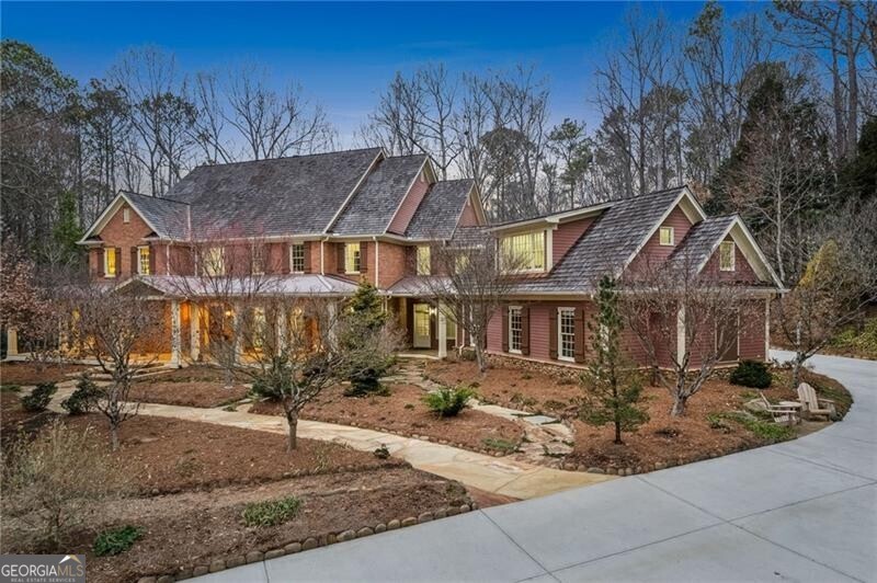 A true entertainer's dream, this private Milton estate in prestigious North Valley offers the perfect blend of luxury, comfort, and natural beauty. As you enter the gated drive, you'll immediately appreciate the privacy and seclusion of this stunning 3.9-acre retreat. Designed to bring people together, this home features expansive indoor and outdoor spaces perfect for hosting unforgettable gatherings. With 11,500 square feet of thoughtfully designed living space across three levels, plus over 1,000 square feet of outdoor areas, there's no shortage of space to entertain. Whether you're hosting an elegant dinner party, a casual cookout, or a cozy evening by the fire, this home has it all. The grand covered front porch, two back decks, charming courtyard garden, and 10 scenic orchard stone seating areas throughout the property provide endless options for guests to relax and enjoy the surroundings. Inside, the open and inviting floor plan is perfect for large gatherings. The living room, with 14-foot floor-to-ceiling windows, offers breathtaking views of the wooded backyard and flowing stream. The dramatic 16-foot vaulted beam sunroom, with light from dawn to dusk has two walls of windows, connects seamlessly to the rear deck and courtyard garden, creating the perfect flow for indoor-outdoor entertaining. Step outside and enjoy the soothing sounds of the 7-foot waterfall cascading into a garden stream-an ideal backdrop for any occasion. The spacious kitchen is a chef's dream, designed to make entertaining effortless. It features granite countertops, a breakfast bar, a six-burner gas range with a pot filler, double ovens, two dishwashers, three sinks, and a beverage center with an ice maker. A large walk-in pantry with built-in storage provides ample space for stocking up on everything you need for hosting. The main floor also includes a luxurious primary suite with a jacuzzi tub, double vanity, separate dressing room, and a private deck with a hot tub-perfect for unwinding after a night of entertaining. Upstairs, four generously sized bedrooms, each with en-suite baths, provide comfortable accommodations for guests. A spacious bonus room offers flexibility for a game room, playroom, or additional gathering space. The terrace level is an entertainer's paradise, featuring two fireplaces, a full kitchen, a game room, media room, exercise room, and TV room. A cherry Williamsburg reproduction cage bar makes hosting even more enjoyable. With additional flex spaces, a bedroom, and a private driveway leading to a workshop, this level is as functional as it is fun. Outside, walking trails lead to scenic seating areas and a fire pit-perfect for late-night conversations under the stars. Nearly invisible deer fencing encloses the property, and a well- water irrigation system keeps the grounds low-maintenance, so you can focus on enjoying your time with family and friends.