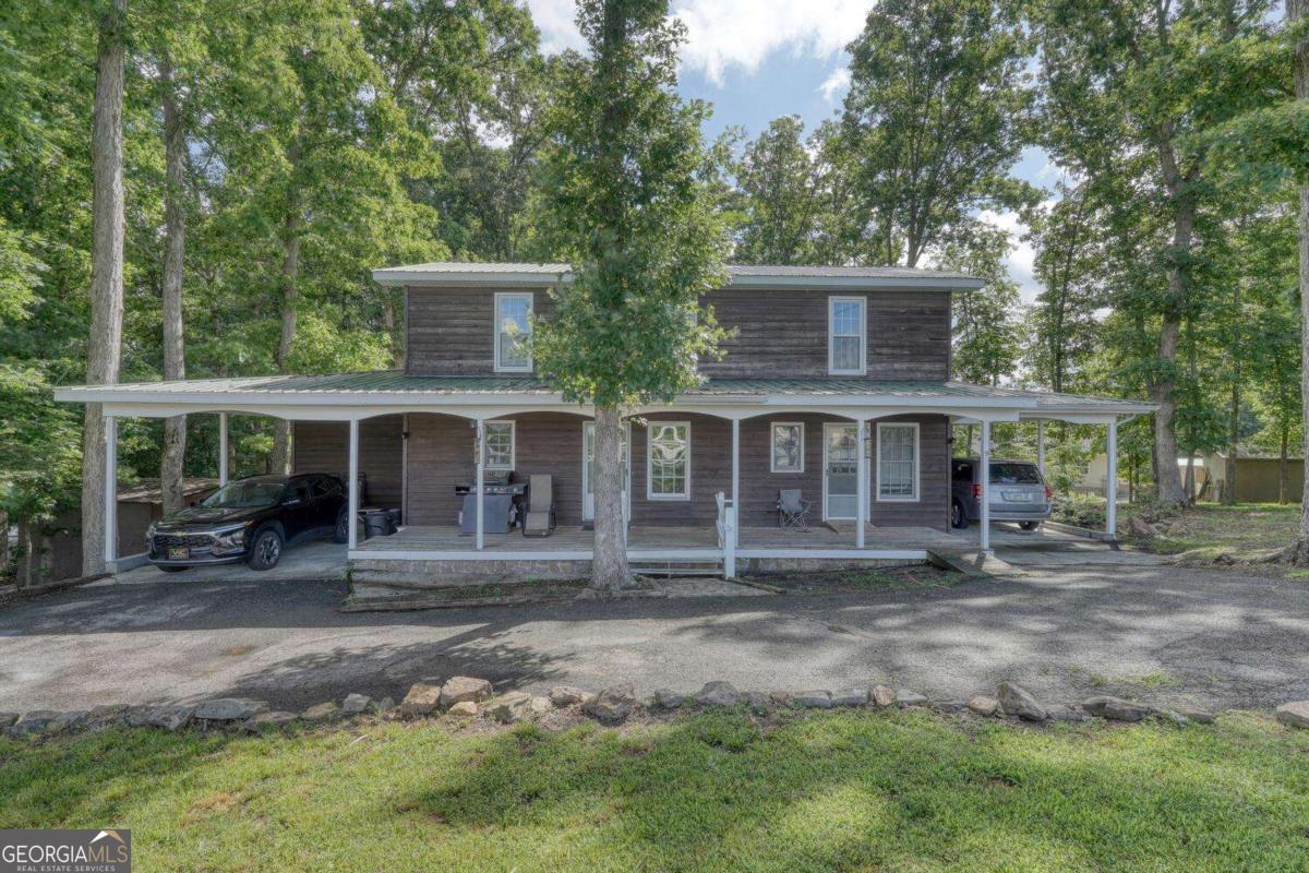 Loads of potential! Motivated Sellers! Located on the peaceful north side of town near the shores of Lake Nottely, this unique property offers two complete living spaces under one roof-perfect for multi-generational living, rental potential, or guest accommodations. This home features two master suites, two full kitchens, two laundry room, and two covered carports, providing comfort and privacy for all. Step outside to enjoy the brand-new back deck overlooking a quiet neighborhood with seasonal views of the surrounding mountains and nearby pastureland. Whether you're soaking in the serenity or entertaining family and friends, this home offers flexibility and charm in a desirable location. Sold AS IS.