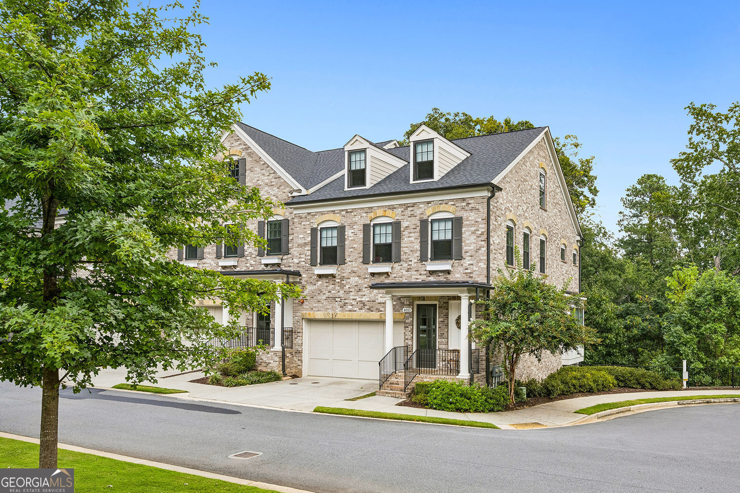 Welcome to Atwater, one of Sandy Springs' most desirable gated communities, where luxury and convenience come together in an unbeatable location. Just a short walk to City Springs, City Walk, upscale shopping, and top dining, this like-new end-unit townhome offers refined living with the ease of a private elevator servicing every floor. Step inside from the covered porch into a sunlit foyer that opens to a spacious, open-concept main level. The chef's kitchen is designed for both function and style, featuring high-end stainless steel appliances, a wall-mounted pot filler, quartz countertops with eased edges, a tiled backsplash, 42-inch upper cabinets, and a walk-in pantry. An oversized island overlooks the dining and family rooms, where a gas fireplace creates a warm centerpiece. A French door leads to a screened porch with wooded views-perfect for year-round relaxation. Throughout the home, hardwood floors on all three levels and soaring ceilings (10 feet on the main, 9 feet upstairs and on the terrace level) enhance the sense of space and light. The elegant staircase with stained oak treads leads to a loft-style flex space, ideal for an office or sitting area. Upstairs, the private primary suite includes a spa-like bath with dual quartz vanities, an oversized frameless shower, a large Kohler soaking tub, and a generous walk-in closet. A secondary en-suite bedroom and a spacious laundry room complete the upper level. The terrace level offers a third bedroom and full bath, a second family room, and abundant storage. French door opens to a private patio, extending the living space outdoors. Residents of Atwater enjoy exclusive access to a sparkling community pool, all within a beautifully designed neighborhood built just six years ago with exceptional finishes and architectural detail.