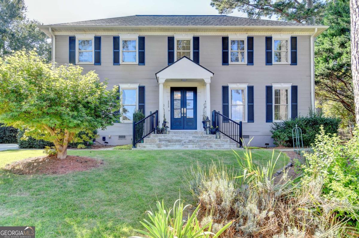 Executive style 5 bedroom, 3 bathroom two-story home. LIVE NEAR LAKE LANIER WITHOUT PAYING TO LIVE ON THE LAKE. Hardwood floors throughout the main level. Updated front entrance/steps with new, beautiful double doors. Entrance foyer leads to formal living room and oversized dining room. Heavy crown moulding and large windows let in plenty of light. Large chef's kitchen with island, double ovens, gas range, extensive cabinetry, and expansive counter space. The breakfast area overlooks the enclosed screened-in back porch. The family room boasts a gas log fireplace and built in bookshelves. Guest bedroom on the main level can also make a great office. The primary suite includes a large walk-in closet and a spa-like bath with oversized whirlpool tub and separate shower. Three large additional bedrooms upstairs include one multi-level suite that could be split in to a 6th bedroom. NEW ROOF/GUTTER GUARDS IN 2025! The rear deck overlooks your private, wooded, fenced-in backyard retreat with your own garden. Public sewer is now available and was installed in the street over the summer. Connection fees have been paid and you only need to have your plumber connect. The lake is just a short walk away! Located minutes from shopping, restaurants, Northeast Georgia Medical Center, and all that the downtown Gainesville Square has to offer.