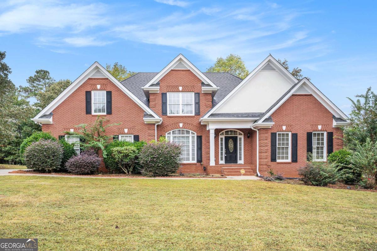 Welcome to 3095 Brombley Dr, a beautifully crafted 4-sided brick home offering 4 bedrooms, 3.5 bathrooms, and an impressive layout designed for both everyday living and entertaining. Perfectly situated on a spacious .44-acre lot, this home blends timeless charm with modern updates in one of Conyers' most convenient and desirable locations. As you enter through the front door, a grand 2-story foyer greets you with elegant sightlines and abundant natural light. To the left is a formal dining room ideal for hosting dinners and gatherings, and to the right, a private office featuring French doors and custom built-in shelving, making it a functional and sophisticated workspace. The heart of the home is the vaulted family room, highlighted by a beautiful fireplace, oversized windows, and an open flow to the kitchen and breakfast area. The eat-in kitchen is both stylish and functional with white cabinetry, granite countertops, a large center island, and stainless steel appliances, including double wall ovens and a gas cooktop-a perfect setup for the home chef. The primary suite on the main level offers a true retreat with a vaulted ceiling, a spa-inspired bathroom with dual vanities, a relaxing jetted soaking tub, a separate shower, and a generous walk-in closet. Upstairs, you'll find three spacious bedrooms with ample closet space and a full bath, creating comfortable accommodations for family or guests. The fully finished terrace level provides endless possibilities and extra living space. It includes a custom bar, game room, bonus/media room, a bedroom, and unfinished storage-perfect for entertaining, multigenerational living, or hobbies. Step outside to enjoy your private backyard oasis. The elevated deck overlooks the yard, ideal for grilling and gatherings, while the covered patio below provides a shaded retreat for relaxing year-round. The spacious yard offers room for play, gardening, or future enhancements. Additional highlights include a 2-car garage, ample storage, and a prime location just minutes from shopping, dining, parks, and easy access to I-20 for a smooth commute. This home combines classic architecture, thoughtful updates, and a flexible floor plan that truly stands out.
