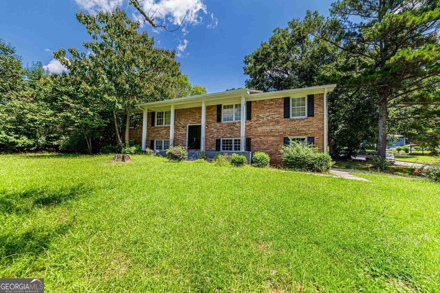 Welcome to Summergate! Tucked away on a corner lot in the Summergate Community, this spacious split-level home sits on nearly half an acre (0.40 acres per tax records) and has been thoughtfully updated.   Freshly painted throughout, the home features an open-concept floor plan with an updated kitchen-white cabinetry, granite countertops, subway tile backsplash, stainless steel appliances (including refrigerator), and a large island perfect for entertaining.  An enclosed sunroom adds even more living space, ideal for year-round gatherings with family and friends.  Upstairs, enjoy three generously sized bedrooms and two full baths. The spacious primary suite boasts a walk-in closet and a stunning ensuite bath with double vanities and a walk-in shower.  The lower level offers a fourth bedroom with a full bath, its own sitting room, and a huge walk-in closet-perfect for guests or a private retreat.  Additional highlights: * Fresh interior paint * Major systems updated around 2020 (HVAC, etc.) * Large laundry room * Two-car garage * Bonus storage room for lawn tools or DIY projects  Located just one block from the neighborhood park and a short drive to East Atlanta Village, Ponce City Market, Downtown Decatur, and Panola & Arabia Mountain trails.  Spacious, stylish, and move-in ready with NO HOA-this home checks all the boxes!