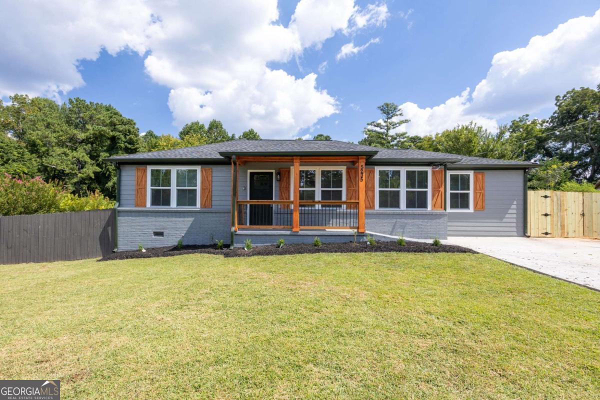 Fully renovated ranch in prime Mableton location! Stunning 4-bedroom, 3-bathroom home, thoughtfully renovated from top to bottom to blend modern style with everyday comfort. Situated on a level lot with a fenced backyard, this home offers low-maintenance living in a convenient and desirable location. Step inside to discover hardwood floors, crown molding, and neutral paint throughout the open-concept living area, where abundant natural light shines. The brand-new eat-in kitchen features an island, soft-close cabinetry, and new stainless steel appliances. The primary suite has a charming beamed ceiling, custom walk-in closet, and a luxurious ensuite bathroom boasting a double vanity, tile shower, and soaking tub. The thoughtful roommate-style floorplan offers two bedrooms with walk-in closets that share a full bath, plus a third bedroom with its own private bath-ideal for guests or multi-generational living. Enjoy outdoor living on the wood deck overlooking the fenced backyard, with plenty of space for pets, play, or gatherings. Additional highlights include a new detached two-car garage, large driveway with ample parking, and all new systems-HVAC, roof, water heater, vapor barrier, and windows-for total peace of mind. Located just minutes from shopping, restaurants, and local attractions, you can walk to concerts and events at Mable House Barnes Amphitheatre. This home truly combines style, convenience, and a vibrant lifestyle. Square footage is approximate.