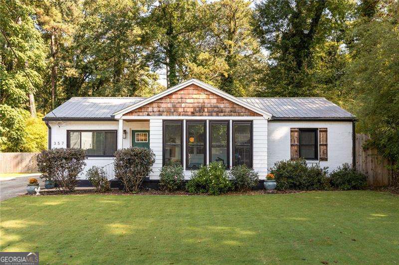 Welcome to this beautifully renovated 1950s gem cherished by the same family since its construction. This home effortlessly blends timeless charm with thoughtful modern updates, making it completely move-in ready. Step inside to an open concept layout where living, dining, and kitchen spaces flow seamlessly, perfect for everyday life and entertaining. Original hardwood floors run throughout, while a fully refinished great room adds warmth and character. The electric fireplace anchors the space, and fresh paint brightens every corner. The chef's kitchen is a true showstopper, featuring a large island, quartz countertops, a dry bar, and abundant cabinetry that feature pull out shelves for easy storage. A spacious pantry tucked just off the mudroom adds extra storage and flexibility, with granite counters, under cabinet lighting, and room for a coffee bar or creative corner. The primary suite offers a moody, intimate retreat with a private bath and soaking tub. Additional bedrooms share an updated hall bath with a large tiled shower, while one sunlit room opens to an enclosed sunroom overlooking the rose garden, perfect for morning coffee or nurturing your green thumb. Set on nearly half an acre, this rare double lot is made for outdoor living. Host friends around the fire pit, cultivate a vegetable garden, enjoy sprawling lawns, or let your creativity run free in the full sized barn ready for chickens or hobbies. Every inch of the yard is yours to enjoy. With every detail thoughtfully updated for modern comfort, this turnkey home combines peaceful privacy with easy access to Hapeville's best dining, shopping, and quick routes to downtown Atlanta and Hartsfield Jackson International Airport. This is a rare opportunity to live, entertain, and create in a home designed for a lifestyle that is all your own.