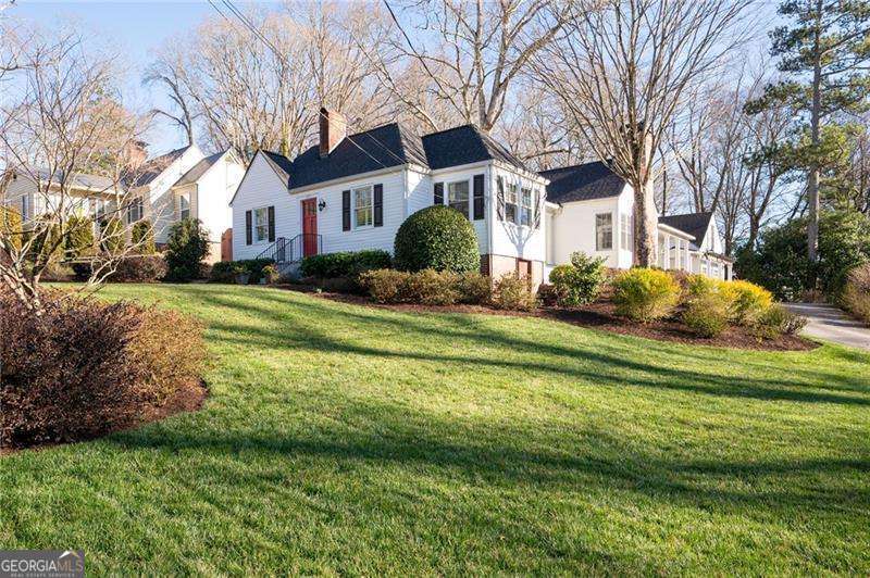 Featured in the book "Marietta - The Gem City of Georgia" as well as having been on the Tour of Homes, this well appointed GEM on Maple Ave is quite the catch! More recently this house has become known for its beautiful landscape that could easily win Yard of The Month every month! With the pristine landscape, beautiful addition and upgrades including the stately colonnade to the carriage house w/ 2 car garage, this home is quite the showstopper on one of MariettaCOs most beloved streets. Inside is just as spectacular with historical details paired perfectly with updated open living. This 3 bedroom 3 bath home (2 bed/2 bath in the almost 2K sq ft main house with another 600 sq ft 3rd bed and bath, in the carriage house) has been meticulously maintained! From the circular drive you will find the back porch entrance overlooking a stunning terrace with a beautiful brick fireplace. Step inside this amazing home and see the spacious family room with vaulted ceilings with wainscoting & the 2nd of 3 fireplaces. 2 lovely built-in bench seats flank the fireplace giving you a perfect spot to curl up with a good book. The family room is open to the kitchen separated slightly by 2 more beautiful columns and clever architectural details that make this home such a unique and stylish space. The custom built island is the heart of this kitchen w/ glass front cabinets, fabulous molding & lighting inside as well as under the cabinets. Dining room has built-in bench seating & recessed cabinetry that is a beautiful reminder of the great history of the home and the details of that era. There is also a side porch, the perfect spot to sit and enjoy sunset. Wandering on to the front of the home you will find the formal living room w/ 3rd fireplace & gas logs as well as a built-in bookcase leading to cheery office w/ so many windows, built-in desk & beautiful wood paneling. The primary suite is on the back of the home giving you great privacy, w/ french doors that lead out onto the back porch overlooking the terrace. Private bathroom w/ custom cabinets that will give you a place for everything along w/ a walk in closet. 2nd bedroom on the front of the home adjacent to hall bath which features walk-in shower all updated in classic tiles that will never go out of style! A back hall connects both bedrooms to the laundry room and additional closet space as well as a built-in pantry. Beautifully restored hardwood floors & plantation shutters throughout the main house show how no detail has been overlooked. Just steps from the back porch is the most amazing terrace w/ fireplace and even a second patio area with a large brick outdoor kitchen complete with a gas grill and sink. The mixture of bricks and natural stones give such a warmth and nod to timely elegance rarely found these days. You can access the carriage house from the back terrace or with just a few steps through the colonnade that takes you into the garage and to the staircase leading you to the 3rd bedroom and private bath with great storage. This could be a perfect STR. Garage has room for 2 cars as well as work space. This house is a must see and you will not believe the yard come spring when everything start to bloom. Lots of great flowering bushes make it easy to maintain. So much love and care has been put into this yard, including a sprinkler system. The main house also features a fire sprinkler system, brand new roof, and exterior paint. HVAC and water heaters have been replaced in the last few years so nothing to worry about in this lovely home. Now letCOs talk about the location!! Maple Ave is sought after for many reasons, top schools being one, but the holiday orbs turn this street into a winter wonderland. The Halloween parade is a must see! A short stroll to the Marietta Square w/ the fun concerts, festivals, amazing restaurants and shopping. The MTR trail & the Kennesaw Mt Nat'l Park all right in the area. It really doesnCOt get any better than 255 Maple Ave!