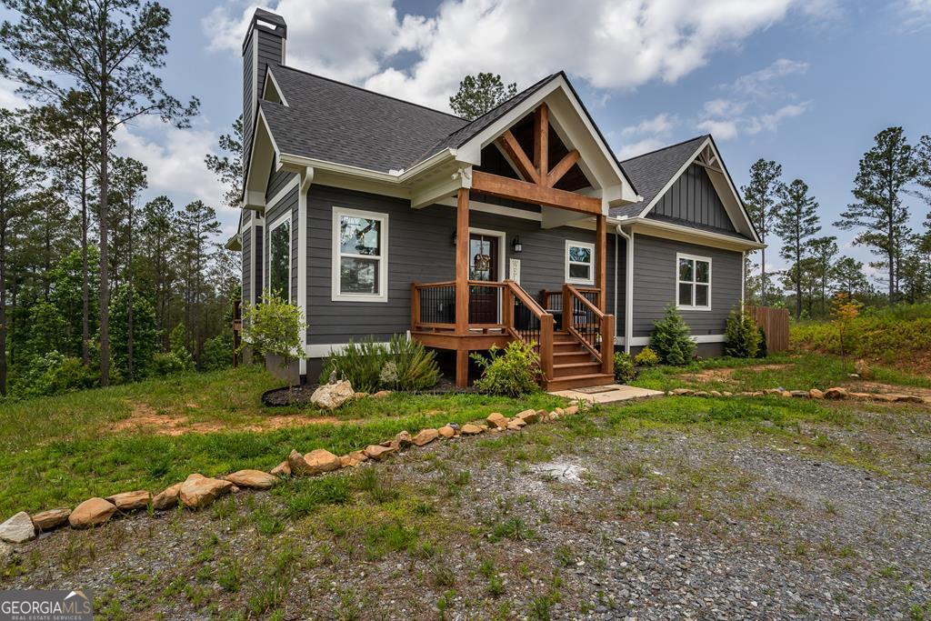 Modern meets rustic in this spacious open floor plan home with soaring ceilings and plentiful windows....and all on one level! Beautiful long range views can be enjoyed from the oversized back deck and throughout this lovely home. Warm up beside the stacked stoned wood burning fireplace on those chilly North Georgia nights or the firepit in the back yard. Beautiful kitchen is a Chef's delight with stone counter tops, gas range, vent hood, farm sink & center island. Enjoy meals in the dining area with large windows to take in nature's views. Abundant owner's suite has tiled walk-in shower, soaking tub and walk-in closet. Large guest bedroom would also make a perfect office space, craft or exercise room. Huge laundry room with cabinets and closet is just down the hall from the kitchen. Stand up crawl space can be used for extra storage. Fenced in side yard is perfect for furry friends and kids to play. Located in sought after gated community with clubhouse, creek access and paved roads, you will love the vibe in the community. Come visit for a moment, stay for a lifetime! Part-time, full-time or short-term rental! Move-in ready so don't wait!