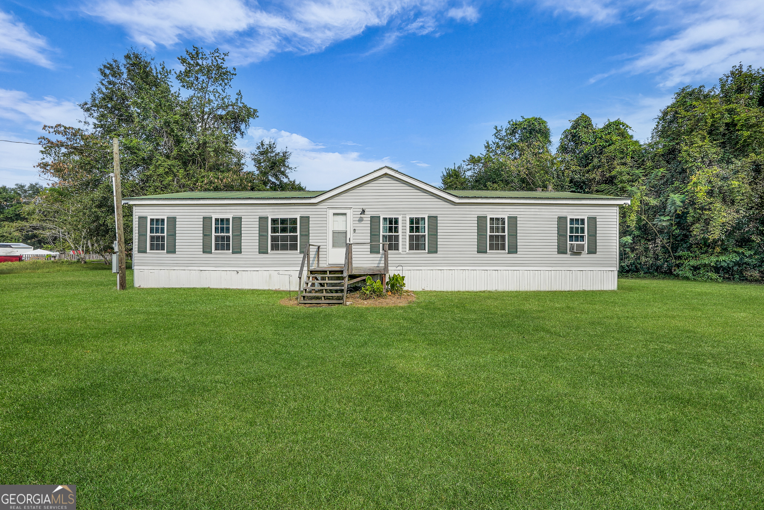 Welcome to 15 Meadowbrook, a spacious 4-bedroom, 2-bath mobile home situated on over half an acre in Ellabell. This property offers plenty of room both inside and out-perfect for those looking for affordable living with space to grow. Inside, you'll find a functional layout with a large living area, an open kitchen with plenty of cabinet space, and a dining area ideal for family gatherings. The primary suite includes a private bathroom, while three additional bedrooms provide flexibility for family, guests, or even a home office. Outside, enjoy the benefits of a large lot-room for gardening, outdoor entertaining, or simply relaxing with privacy. With no HOA restrictions and easy access to Pooler, Savannah, and the new Hyundai plant area, this home combines convenience with country charm.