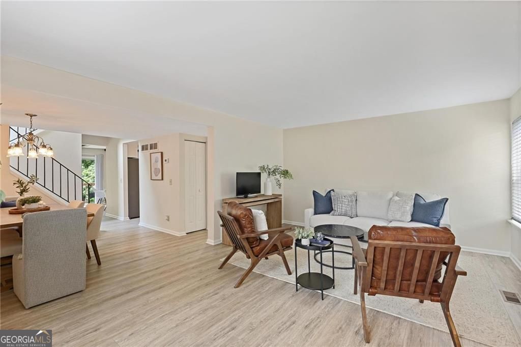 Welcome to 2117 Bucktrout Place, a spacious 3-bedroom, 2.5-bath townhome with a full finished basement-offering both style and versatility. Step inside through a striking marble-tiled foyer into a beautifully updated main level featuring brand-new LVP flooring and fresh paint throughout. The layout includes a beamed-ceiling flex space with a private deck overlooking serene natural views, a centrally located kitchen with a brand-new refrigerator and dishwasher, a dedicated dining area, and a generous living room. Upstairs, a large picture window floods the stairwell with light and frames a lush, green view. The second level offers a versatile loft space-ideal for a home office-along with a spacious primary suite, two additional bedrooms, a full hall bath, and generous closet/storage space throughout. The finished terrace level is perfect for entertaining, featuring a wet bar, a flexible living space that opens to a private enclosed patio, and a bonus room ideal for a game room or media area. A separate laundry room completes this level. Located just minutes from Brook Run Park with easy access to I-285, I-85, and GA-400, this home offers exceptional space, comfort, and convenience. Endless potential awaits in this one-of-a-kind end unit!
