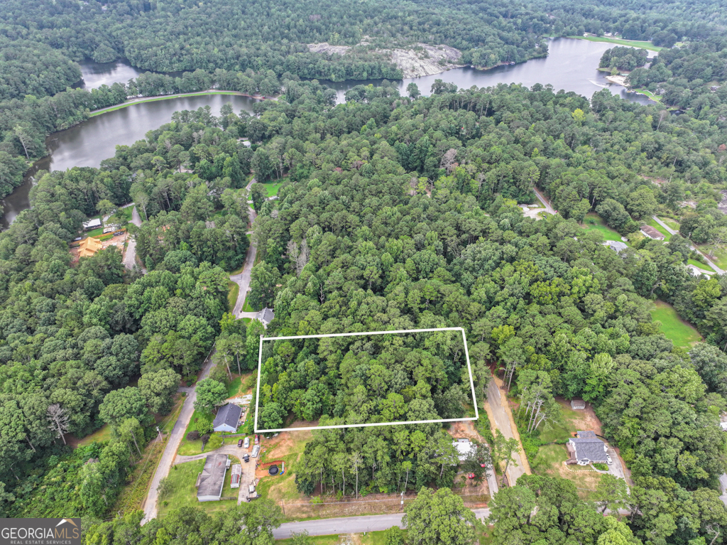 Looking to build your forever home in a lake community? Looking to invest in land? Here is your chance! Buildable lots like this rarely come available. Check out this 0.92-acre lot in Hi Roc Shores subdivision. This is one parcel but makes up 4 lots. The lot is gently sloped and would be great for a basement home! Lot is wooded with mature trees. Only two streets away from the 55 +/- acre Rockdale Lake where you can fish, jet ski, boat, picnic, beach and simply relax! All utilities would need to be installed on lot, but the infrastructure is available. The HOA has installed the private road to gain direct access to lot. The community has two industrial wells for water. Close to restaurants, shopping and downtown Conyers and minutes to I-20.