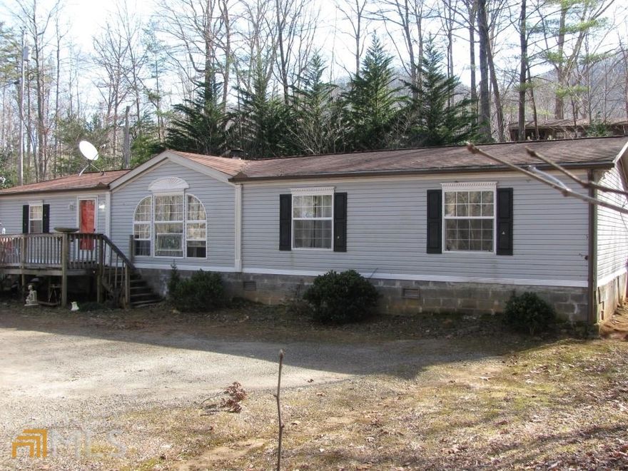 **One level 3 bedroom 2 bath manufactured home in Bald Mountain Park**Has concrete block perimeter foundation**Towns County tax record shows dwelling size is 28'x66'**Located on wooded 1.302 acre lot**Split plan layout with Master Suite with very large master bath, library or office space all on one end**2 bedrooms with another full bath on other end**This has large living room with real wood burning fireplace**Separate dining room and eat-in kitchen with breakfast area**Laundry room off kitchen with door to the back open deck with metal storage shed**Affordable one level home in the North Georgia Mountains for full time or vacation living**