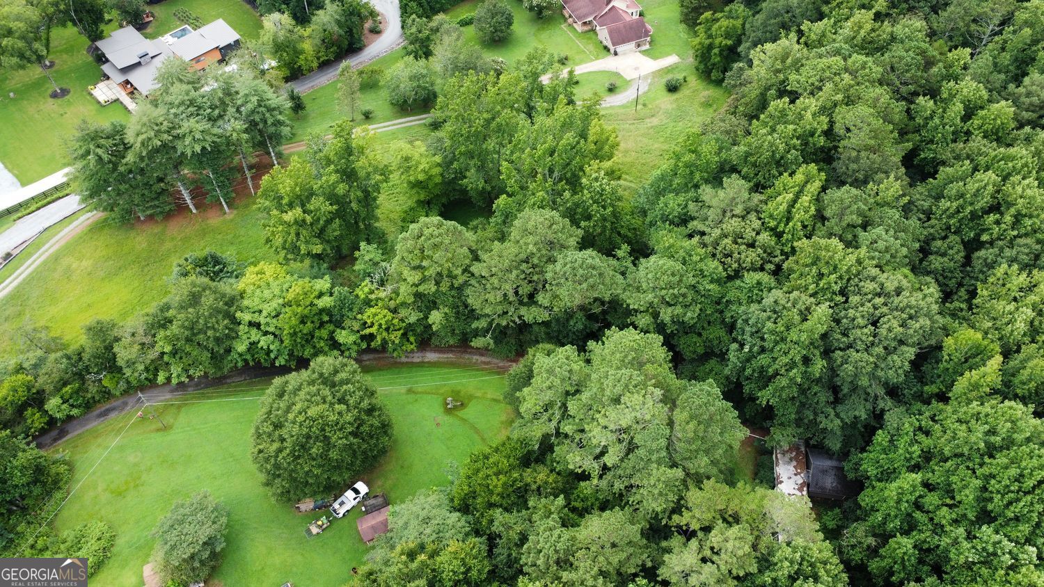 Discover the Charm of 2626 Hickory Road Holly Springs, GA Welcome to 2626 Hickory Road-a rare opportunity to own 4.96 acres of peaceful, scenic land in the heart of Canton, Georgia. Perfectly priced and unmatched in value, this property offers a blank canvas for your dream home or next development project. Located in the highly sought-after Sequoyah High School district, this location blends top-tier education with a strong sense of community, making it ideal for families. Nature lovers will appreciate the proximity to J.B. Owens Park, just steps away, featuring modern amenities and tranquil walking trails. Enjoy the perfect balance of serenity and convenience: just 2.7 miles from Downtown Holly Springs and the exciting upcoming Town Center, promising a vibrant mix of shops, dining, and entertainment. Everyday essentials are also within easy reach-Publix, Kroger, Starbucks, Hickory Flat, Bradshaw Farm Golf Club, and Alpha Equestrian Center are all within a 3-mile radius. Commuting is simple with nearby access to I-575, connecting you seamlessly to Cherokee County and the greater Atlanta area. The property already has electricity connected to Tract 2, and an existing mobile home on-site offers flexibility for temporary living or a construction base. Whether you're looking to build a private retreat or explore development potential, this is your chance to own land in one of Cherokee County's most desirable and fast-growing areas. Don't miss out-make 2626 Hickory Road the foundation for your next chapter. Also listed as mobile home (7627183)