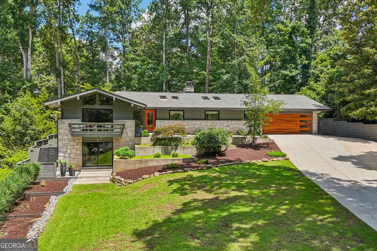 Welcome to this fully renovated, light-filled mid-century retreat, nestled in the highly desirable Riverside neighborhood of Sandy Springs. Reimagined with style, function, and comfort in mind, this home features a spacious open floor plan, high-end finishes, and thoughtful upgrades throughout. Step inside to discover expansive living spaces bathed in natural light from oversized windows, skylights, and sliding glass doors that frame serene backyard views. The heart of the home is the new gourmet kitchen outfitted with Cambria countertops, stainless steel appliances, and added pantry space-all overlooking the elegant dining area and living spaces. An impressive 600-square-foot addition off the back of the home introduces even more living space with soaring ceilings, a striking stone fireplace, and windows that bring the outdoors in. Enjoy the serene patio space and the private fenced backyard - a true outdoor sanctuary with lush landscpaing, a fire-pit and plenty of room for relaxing or entertaining. The main level further includes a spacious primary suite with walk-in closet and a beautifully updated primary bath with heated floors, skylights and marble shower. The fully finished walkout, daylight basement offers incredible flexibility-perfect as a nanny or in-law suite-with a kitchenette, full bath, bedroom, living area, and additional storage. A newly added 2-car garage provides convenience and extra storage, while the widened driveway allows for additional parking. Every detail of this home has been carefully curated for modern living-combining contemporary elegance with practical luxury in a peaceful setting.