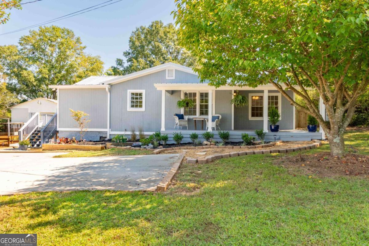 Charming Renovated Home with Modern Amenities Come enjoy your newly renovated 3-bedroom, 2-bath home tucked away on .69 acres. You'll love the inviting rocking chair front porch, perfect for relaxing and enjoying the outdoors. The home features a split bedroom plan and a cozy living room, providing both privacy and comfort. The light and bright kitchen is a chef's dream, boasting white slow close shaker-style cabinets, granite counters, and all new stainless steel appliances including a range, microwave, refrigerator, and dishwasher. The newly added primary bath includes tiled floors, a dual vanity, shower, and walk-in closet, while the secondary bath features tiled floors, a vanity, and a shower/tub combo. Luxury Vinyl Plank (LVP) flooring runs throughout the main living areas, kitchen, and bedrooms, adding a modern touch. The side deck, which wraps around the house, is ideal for BBQs and outdoor relaxation. Additionally, the newly poured concrete parking pad with extra gravel parking ensures ample space for vehicles. This home also has extra storage in the unfinished basement. This property is a contractor's or landscaper's dream, with multiple storage barns and a large 28ft x 38ft workshop with covered RV storage. Don't miss your opportunity to own this exceptional home!