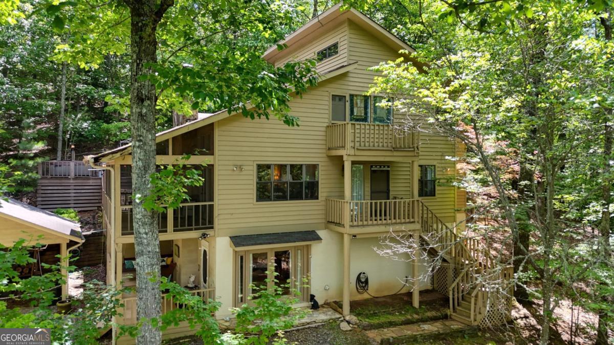 Charming Private Mountain Retreat with Endless Potential! Nestled on 5 unrestricted, private acres, this serene property is a wildlife lover's dream-deer and other wildlife abound, offering a peaceful connection to nature. Enjoy breathtaking year-round mountain views that will become truly spectacular with a bit of selective tree clearing. The home is thoughtfully designed with sleeping areas on every level: two comfortable bedrooms on the main floor and a spacious master suite upstairs. Adjacent to the master is a large flex space, perfect for a walk-in closet, craft room, or home office-tailor it to your lifestyle. Relax and unwind on the screened porch or the upper deck, complete with a hot tub where you can soak in the stunning vistas. The fenced backyard is ideal for your furry friends to roam safely. Convenience abounds with two driveways providing easy access, ample outdoor storage, and a handy tool shed near the carport. Additionally, there's covered parking designed to accommodate a camper, RV, or boat, featuring an attached workshop for all your projects and hobbies. This home is being sold "as-is," offering a fantastic opportunity for those ready to add their personal touch and make it shine like new. With endless possibilities on this spacious, unrestricted acreage, your dream mountain retreat awaits.