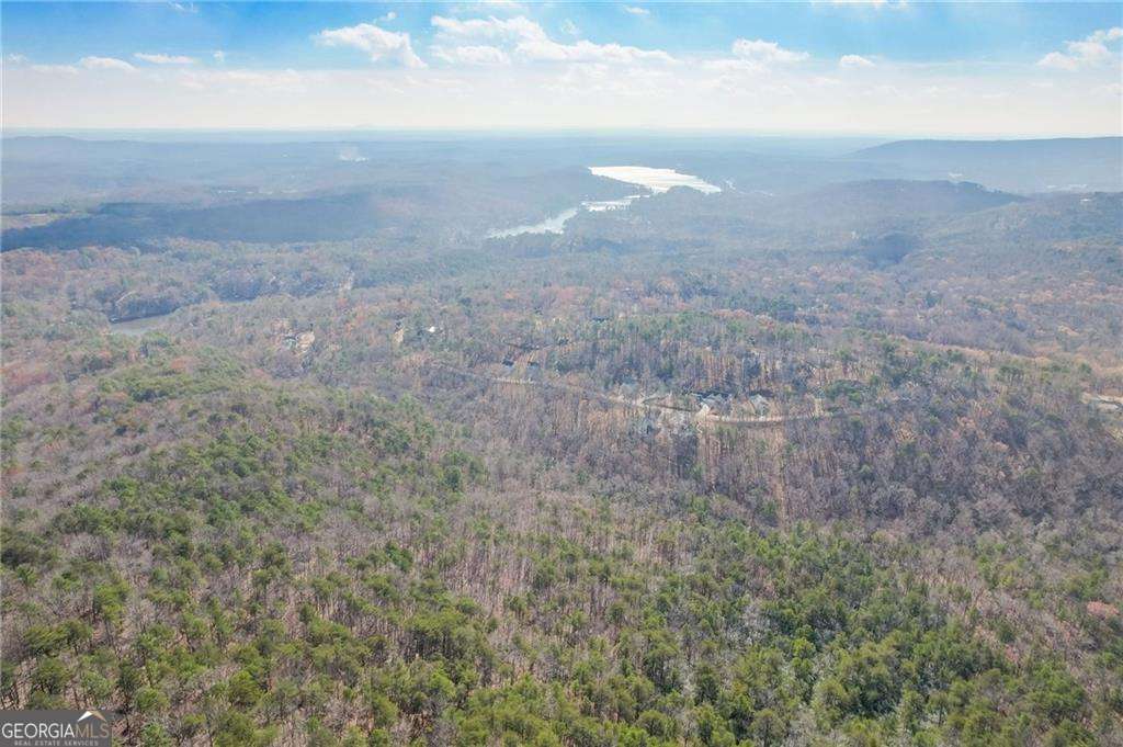 Welcome to this extraordinary opportunity to own 330+ acres of pristine land in the stunning north Cherokee County Mountains. Prepare to be captivated by the breathtaking panoramic views of the iconic Atlanta skyline that await you from this magnificent property. Natural rock bluffs dot the landscape, providing awe-inspiring vistas of the surrounding mountains, lakes, and the Metro Atlanta area. With its vast expanse and untouched beauty, this property presents an ideal setting for development. Its size and topography make it perfect for creating 5-acre lots, allowing for spacious homes and ample room for families to build their dream compound. Alternatively, for those seeking a long-term investment in the ever-growing real estate market, this property holds tremendous potential. As Metro Atlanta continues to expand towards the mountains, this land could serve as a valuable landholding, offering future opportunities for development and appreciation. A gravel road winds its way through the captivating terrain, granting you seamless access to explore the stunning surroundings. Multiple recreation vehicle trails are dispersed throughout the expansive 330-plus acres, providing endless possibilities for outdoor enthusiasts to embrace nature at its finest. The property boasts creeks and natural springs, providing opportunities to create serene lakes that would further enhance the already remarkable natural beauty of this one-of-a-kind estate. One section of the property is thoughtfully fenced, making it ideal for horses. Additionally, a charming 3-bedroom, 2-bathroom caretaker home is nestled on the land, presenting the perfect opportunity for rental income or as a comfortable hunting camp.