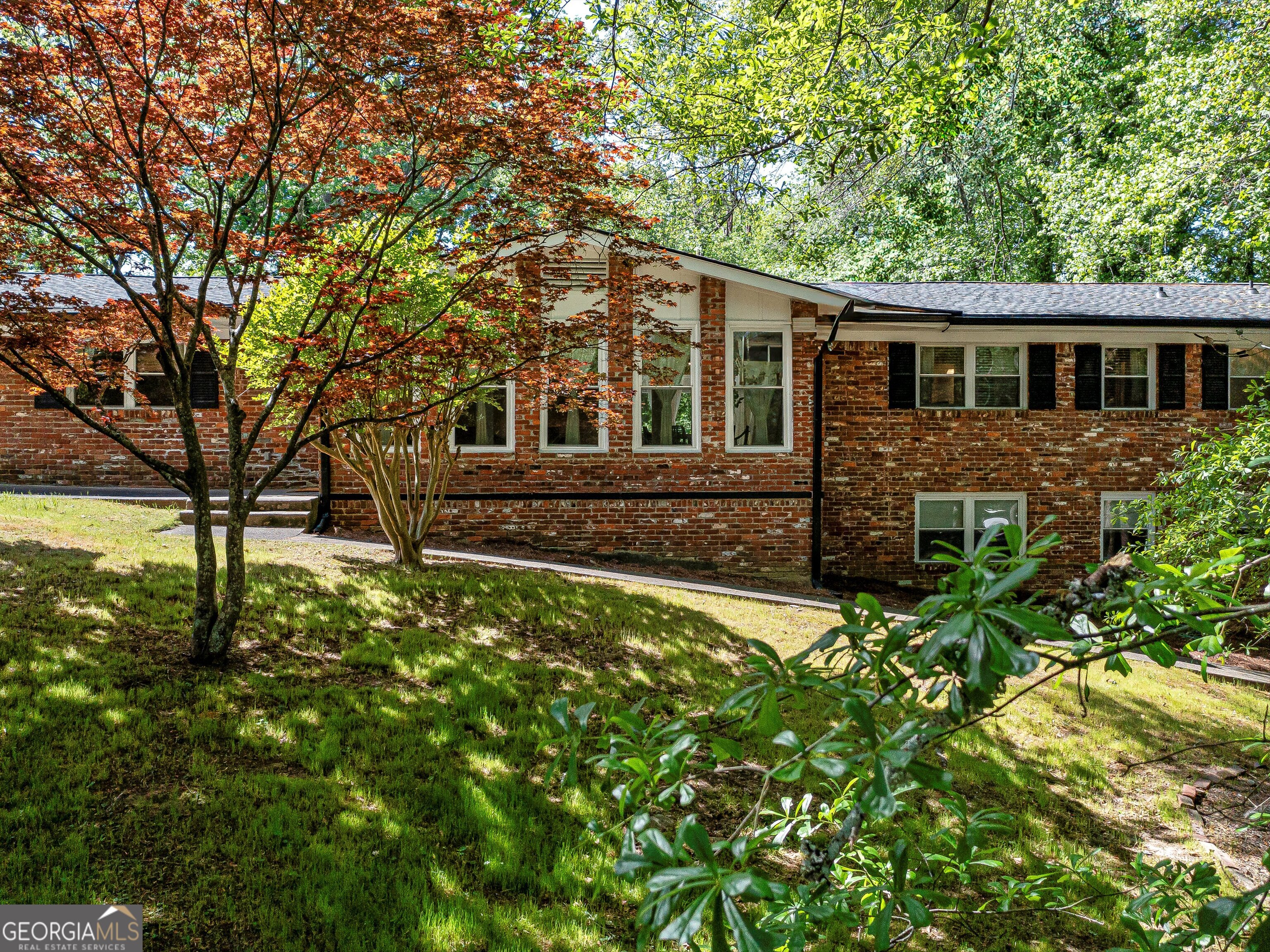 Owner Relocating - Priced Below Appraised Value! Plus, enjoy a $10,000 buyer incentive to use toward a rate buy-down, closing costs, or however you choose! Welcome to this stunning 4-sided brick Mid-Century Modern Ranch in the desirable Peyton Forest neighborhood of Southwest Atlanta, near Cascade Heights. Sitting on a private wooded lot with two driveways and rear-entry garage, this beautifully updated home offers the perfect blend of charm, space, and modern convenience. Inside, the main level features all-natural hardwood floors (no carpet!), an open-concept layout, and floor-to-ceiling windows in the family room that overlook a serene backyard oasis. The updated kitchen includes quartz countertops, soft-close cabinetry, a pantry, eat-in area, and stainless steel appliances with views into the family room. A formal dining and living room offer additional space for entertaining. The main level hosts 3 bedrooms and 2 full baths, including an owner's suite with quartz counters, a custom closet, and a spa-inspired bath with marble flooring and a beautifully tiled shower. The fully finished terrace level is ideal for multi-generational living or additional income-featuring new LVP flooring, a second full kitchen with stainless steel appliances, 2 bedrooms, 1 full bath, a media room, and spacious open areas for entertaining or relaxing. This home has been completely updated, including a new roof, new HVAC, modern lighting fixtures, and fresh paint throughout. Don't miss your chance to own this gorgeous, move-in ready home under appraised value-with $10,000 in incentives waiting for you!
