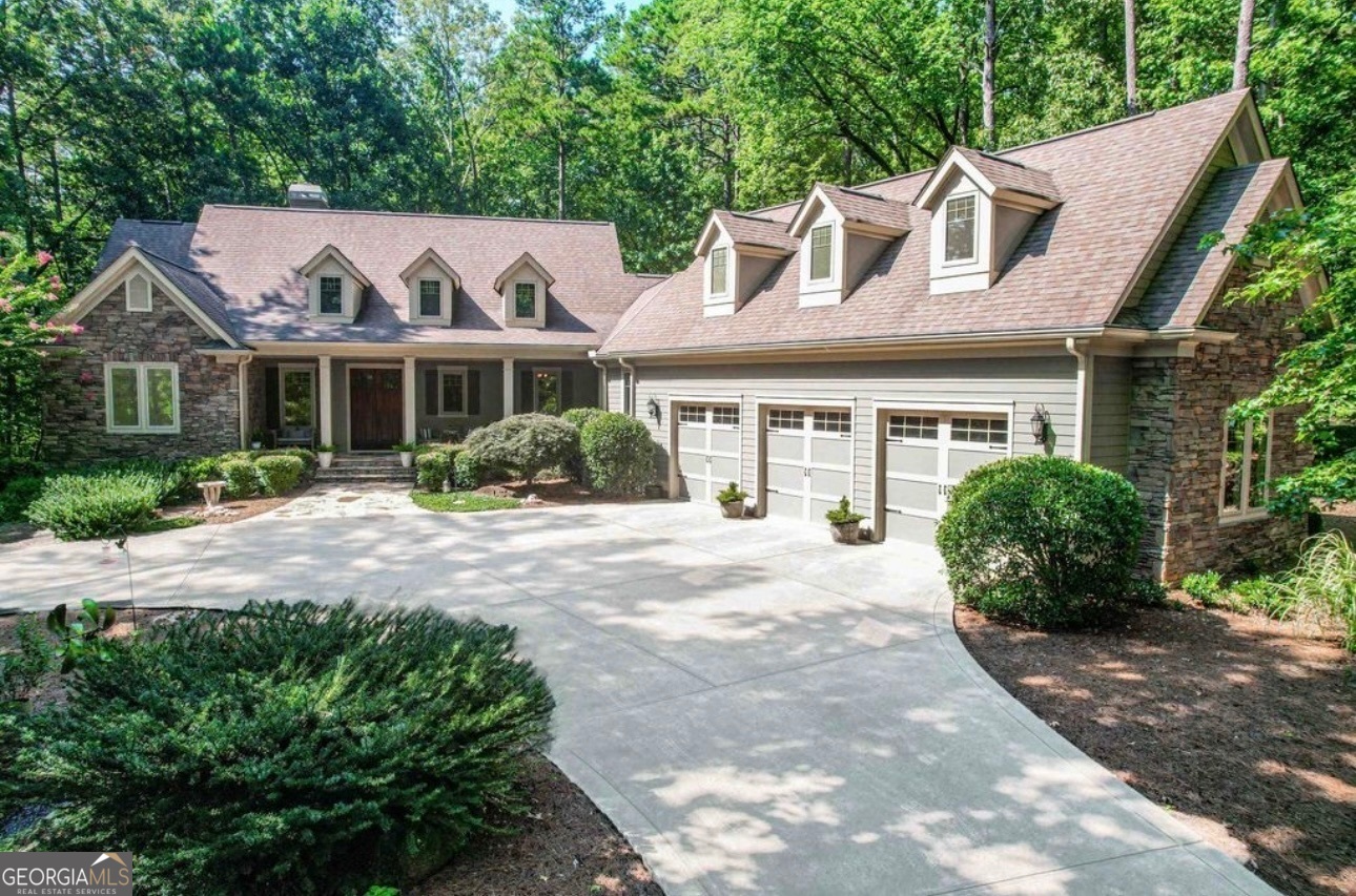 Beautiful surroundings and outstanding location. Your own private oasis....over 2 acres in the most desirable area of Reynolds at Lake Oconee. You can enjoy all Reynolds has to offer in this beautiful 5,500 square foot home on your own private, landscaped park-like 2.21 acres. This gorgeous home is nestled in one of Reynolds' most sought-after locations. This craftsman built home boasts 5 bedrooms, 4.5 baths, and over 5,500 square feet of elegant living space. All quality construction including Pella windows throughout. Upon entering, the soaring ceilings and abundant natural light of the open living area immediately captivate. The great room features a striking stacked stone fireplace and custom built-in bookcases, seamlessly connected to the spacious dining room with modern lighting and enhanced trim details. The chef's kitchen and adjoining keeping room are designed for both intimate gatherings and gourmet entertaining, offering style and functionality. Does your client want a larger kitchen? (no problem) a rendering is included of a kitchen with island that would be easy to change - use the current dining room and convert the kitchen to a wetbar/butler's pantery and the keeping room to a formal dining room. (a rendering is in the pics). Relax and unwind on the screened porch, overlooking the serene, fenced backyard and wooded surroundings. The primary suite on the main level is a true retreat, with a beautifully updated bath and dual custom walk-in closets. Upstairs, a versatile guest suite/flex space above the garage features a full bath, sitting area, and custom walk-in closet - ideal for extended stays or private relaxation. The lower level is an entertainer's dream, complete with a spacious great room, a wet bar equipped with a mini fridge and microwave, and access to a covered flagstone patio for additional outdoor living. This level also includes two large bedrooms with private baths and a fully equipped gym (or optional home office/5th bedroom). The fenced backyard is a place pets will love. Additional highlights include: Expansive 3-car garage with exceptional storage. Numerous updates, including: Exterior painting, Remodeled primary bath, New kitchen countertops and backsplash, Fresh interior paint, Expanded hardwood flooring. Finished gym/flex space, New carpeting and more. This home represents exceptional value in Reynolds and offers the perfect blend of luxury and practicality. A Reynolds Membership is available for purchase, making this property an even more enticing opportunity. Don't miss your chance to tour this remarkable home - schedule your visit today! (Owner is a licensed Georgia Real Estate agent.)