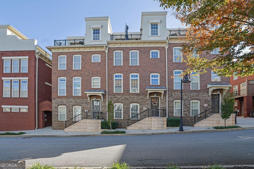 Enjoy the opportunity to live within walking distance of the vibrant Marietta Square! Where you'll enjoy shopping, dining, and entertainment! This prime location combined with the luxurious features of this home, makes it truly unmatched. Step into this breathtaking four-level townhome offering a spacious and functional layout! The home includes three full bedrooms, each with its own en-suite bath. Plus two additional half baths for convenience. Inside, you'll find hardwood floors throughout, along with recently replaced carpet and paint. Newer HVAC units as well! A full bedroom is conveniently located on the main level. On the second level, you'll notice the chef's kitchen featuring stainless steel appliances, a large island, and an open layout flowing seamlessly into a cozy living area with a gas fireplace and built-in shelving. Perfect for entertaining or relaxing with family! Upper level hosts a luxurious oversized primary suite with a spacious walk-in closet complete with custom built-ins. The spa-like en-suite bath offers dual vanity, walk-in shower, and soaking tub. On the fourth level, you'll find a showstopping bonus area complete with a wet bar and access to your private rooftop patio and rear grilling deck. Enjoy astounding views of Marietta Square and Kennesaw Mountain-a perfect spot to unwind in the evenings or even watch the well known event of Marietta fireworks on July 4th from the comfort of your own home! Additional bonus includes the community offers a pool, dog park, and fire pits! This home is the perfect blend of lifestyle, convenience, and luxury. Come tour this home today!