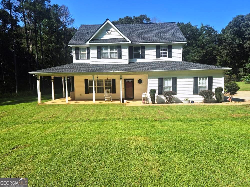 Welcome to this beautiful 8 acre retreat with a charming three sided wrap around covered porch that creates an extended exterior living space. Inside this beautiful, pristine home there is a stone fireplace that is the focal point in the family room that flows into the dining area and kitchen. The kitchen features Stainless appliances (new refrigerator included with sale), Granite countertop and Linear tiled backsplash. This home boast of hardwood flooring through out! Step outside onto the covered porch from the double French Doors to the serene beauty of nature where you will catch deer grazing at dusk. Upstairs to the primary suite with vaulted ceiling, primary Bathroom with seperate shower and jetted spa soaker tub, additional two spacious secondary bedrooms with a BONUS 4th/BEDROOM! Driveway is gated and there is an additional covered carport and two storage outbuildings on the property. With a blend of tranquility yet only minutes from shopping, restaurants and medical facilities...Property also has 2 deerstands in the wooded area.