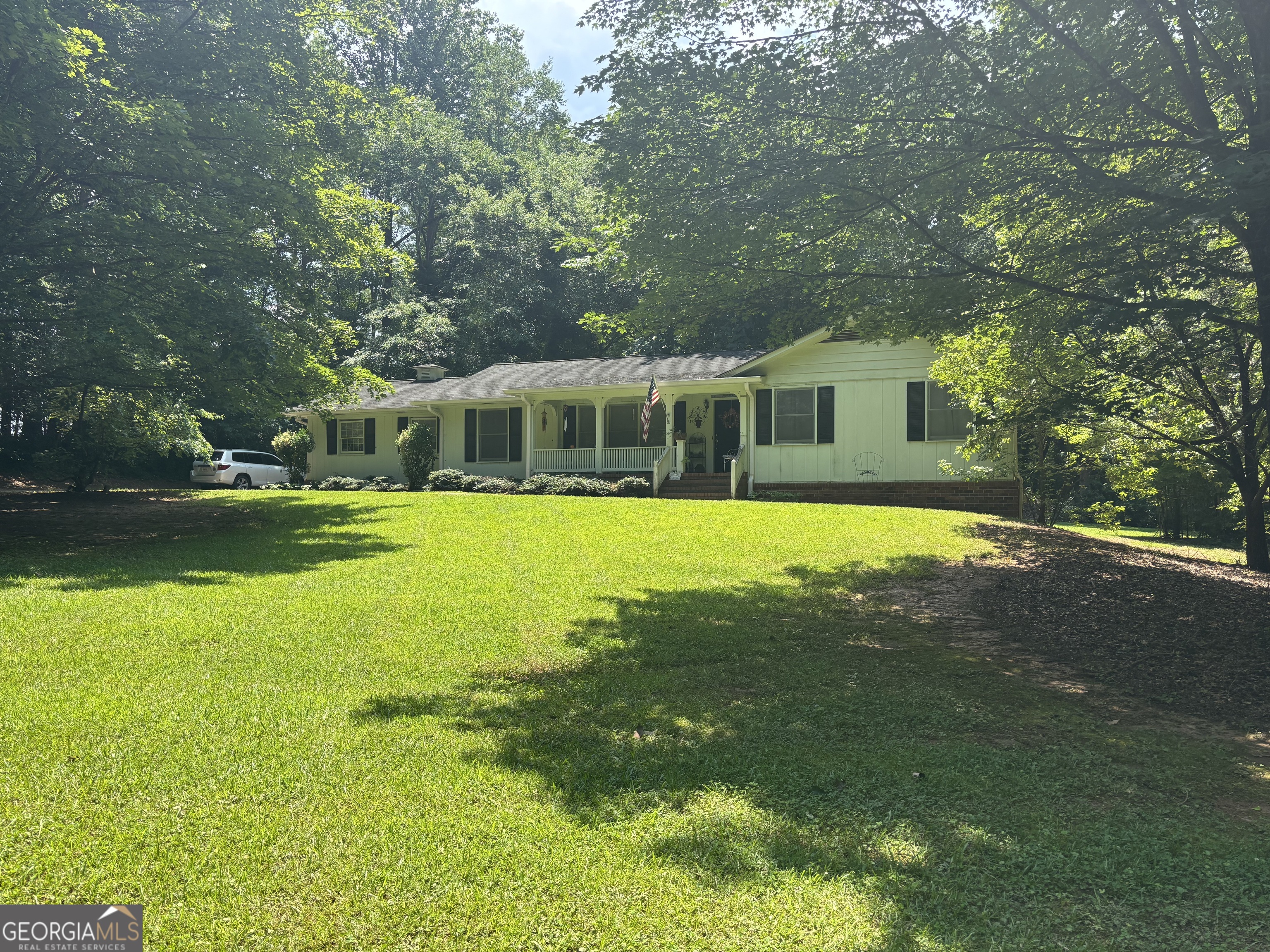 Charming traditional 4 sided brick home, pristinely positioned in the center of a quiet cul-de-sac of an established neighborhood, with an oversized lot of over 1.5 acres. This home boasts charm and functionality with 2 bedrooms upstairs, 2 newly refreshed bathrooms, updated LVP flooring, a bright and welcoming living room with ample natural light, cozy family room/den with beamed ceilings and brick fireplace, formal dining room, functional country kitchen, and laundry room. Downstairs, the full daylight basement has been partially finished, to perfectly accommodate either a flex space, a teen's oasis or in-law suite, complete with full finished bath, fireplace and additional laundry hookups. Relax and unwind after a long day on the inviting front porch, overlooking the gorgeous well maintained lawn. Outside, this large level lot with walking trails and just enough hardwoods to boast privacy as well, offers plenty of space to enjoy the out doors, along with a huge detached 20 X 24 shop or workspace equipped with electricity - ideal for storage or outdoor projects. This home is move in ready and offers plenty of space both inside and out, coupled with it's prime location about 5 minutes north of historic downtown Newnan, definitely will not last long at this price.
