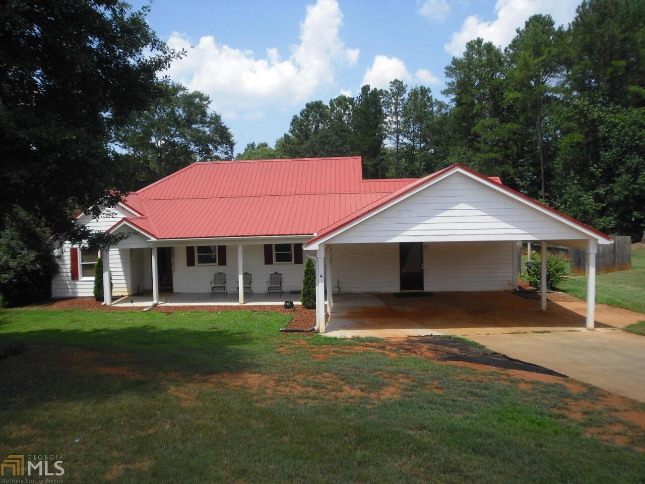 Fantastic find for the price!! Spacious ranch with numerous upgrades throughout. Enlarged covered carport/front porch, foyer entry, large kitchen with tiled flooring, stainless appliances, 4 pantry closets, custom cabinets w/pullouts, sunny breakfast area, large family room featuring fireplace w/remote, oversized master w/ spa bath, tiled shower and tile flooring, huge walk-in closet, two additional bedrooms w/ full tiled bath, 4th bedroom can be fabulous rec room, or second family room, 26X30 detached garage w/power and automatic opener, separate out building, and fenced-in back yard. Definitely "one of a kind" and not to miss!!