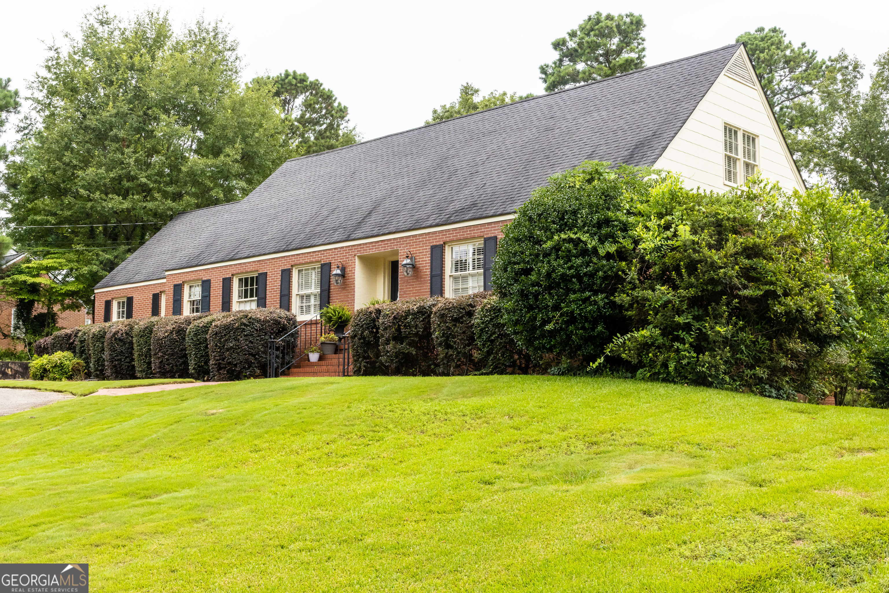 Welcome to this timeless, beautifully designed, custom brick Colonial in the highly sought-after Johnston Heights neighborhood-just up the hill and within walking distance to the hospital, and convenient to everything Thomaston has to offer. Built by the highly respected Frank Binford, this elegant two-story home offers 3,050 square feet of thoughtfully designed living space with classic charm and modern updates. Inside, you'll find 4 spacious bedrooms and 3 full bathrooms, including a main-level owner's suite and a main-level guest bedroom. The two upstairs bedrooms, full bath, and large bonus room have been updated to offer a fresh, functional space for guests, kids, or a home office. Gorgeous hardwood floors flow throughout much of the home, complemented by classic plantation shutters and wide hallways that create an open, airy feel. The heart of the home is a spacious kitchen with an inviting breakfast bar-perfect for morning coffee or casual meals. The kitchen features beautiful granite countertops and custom cabinetry. Just off the kitchen, a cozy family room with a gas-log fireplace offers a warm spot to unwind and features easy access to the backyard, making indoor-outdoor living and entertaining a breeze. The formal living and dining rooms provide elegant space for gathering with family and friends. Outdoors, the beautifully landscaped backyard features a pergola that's ideal for relaxing, grilling, or watching the game with friends. A partial basement with a concrete floor provides excellent storage, and the attached garage with remote entry adds everyday convenience. Additional upgrades include two HVAC units, an architectural shingled roof, updated electrical and water heater (2018), and fresh exterior paint. This well-loved home blends character, comfort, and quality-and is a true must-see for anyone looking to put down roots in one of Thomaston's most prestigious neighborhoods.